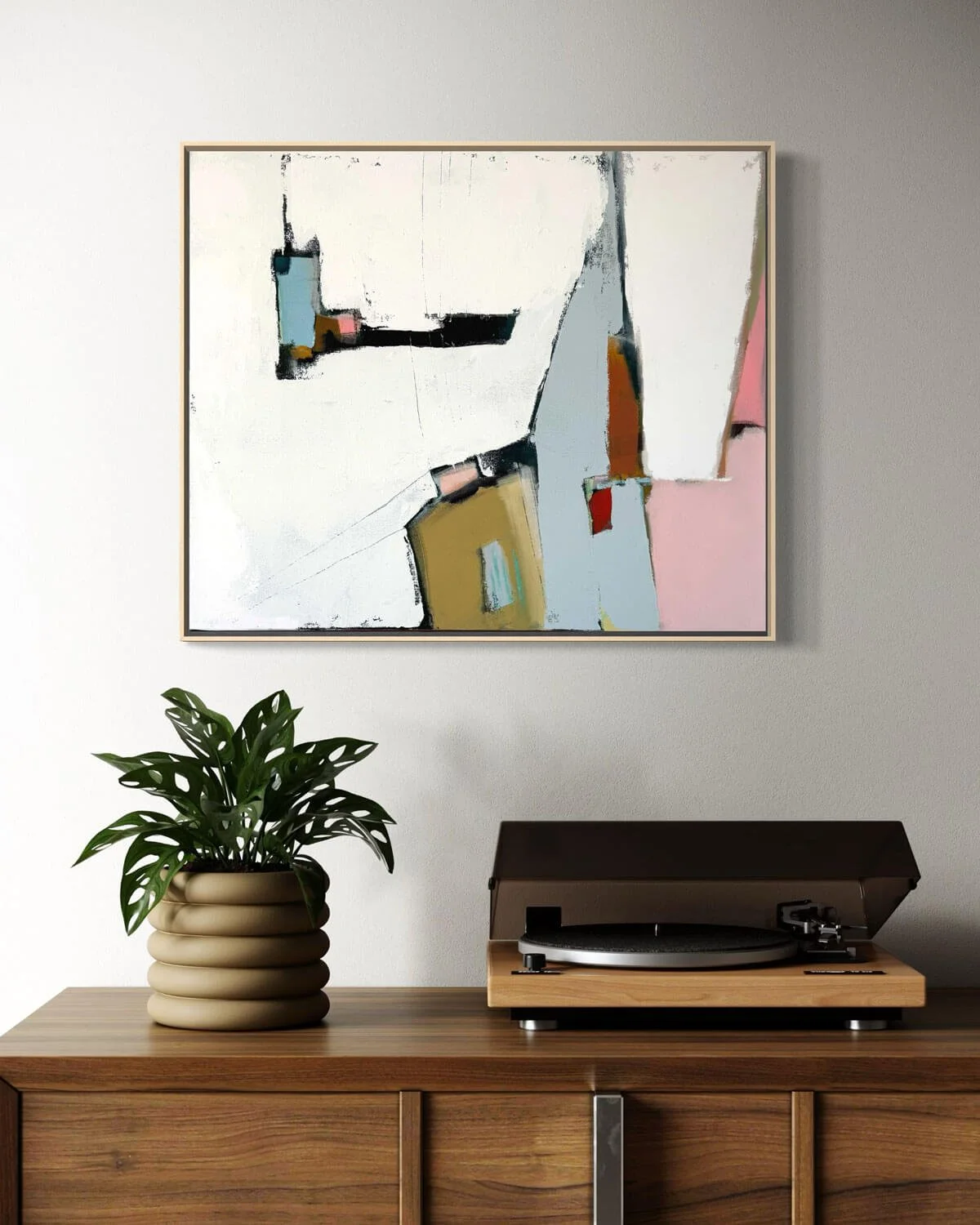 Abstract painting titled Holding the Moment hanging above a record player