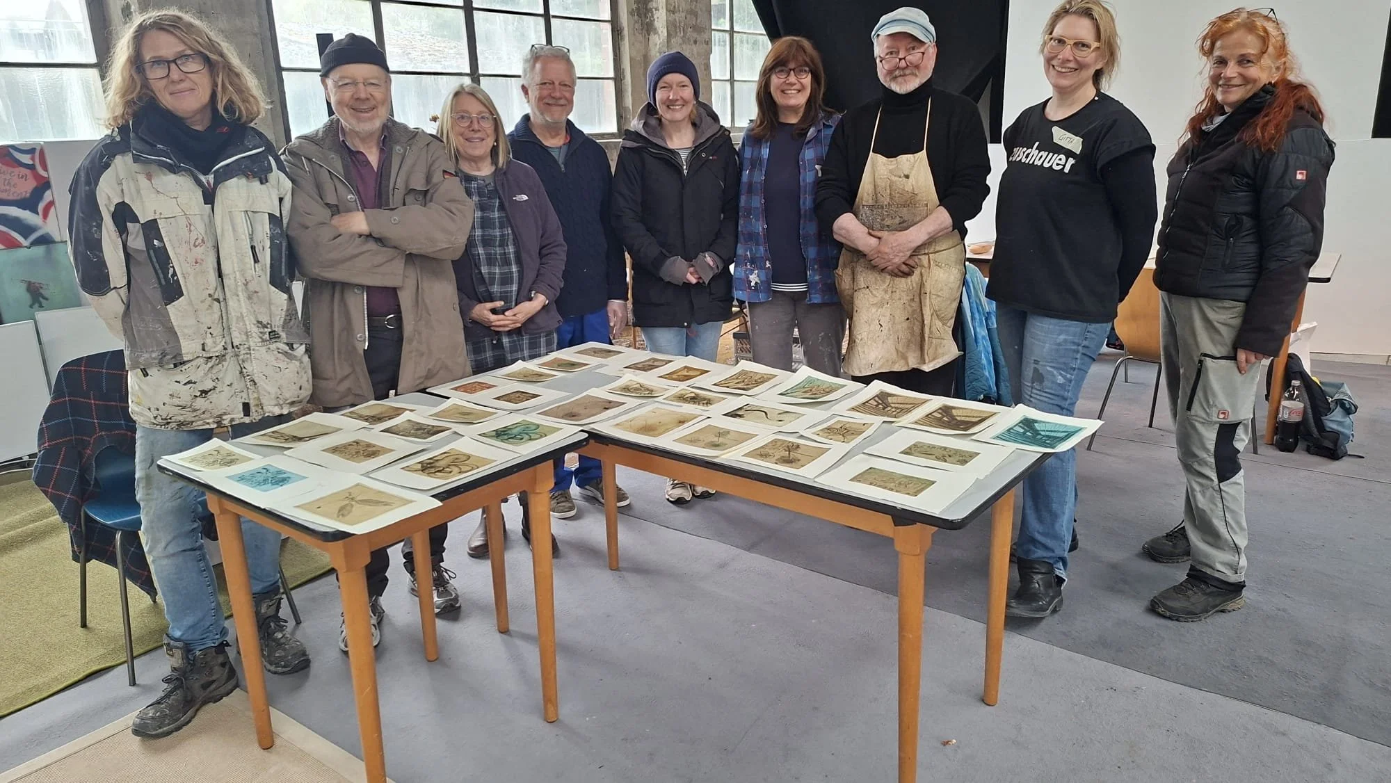 Zum Abschluss wollten wir noch ein Gruppenbild machen und es stehen alle mit Norbert hinter einem Tisch mit allen Drucken