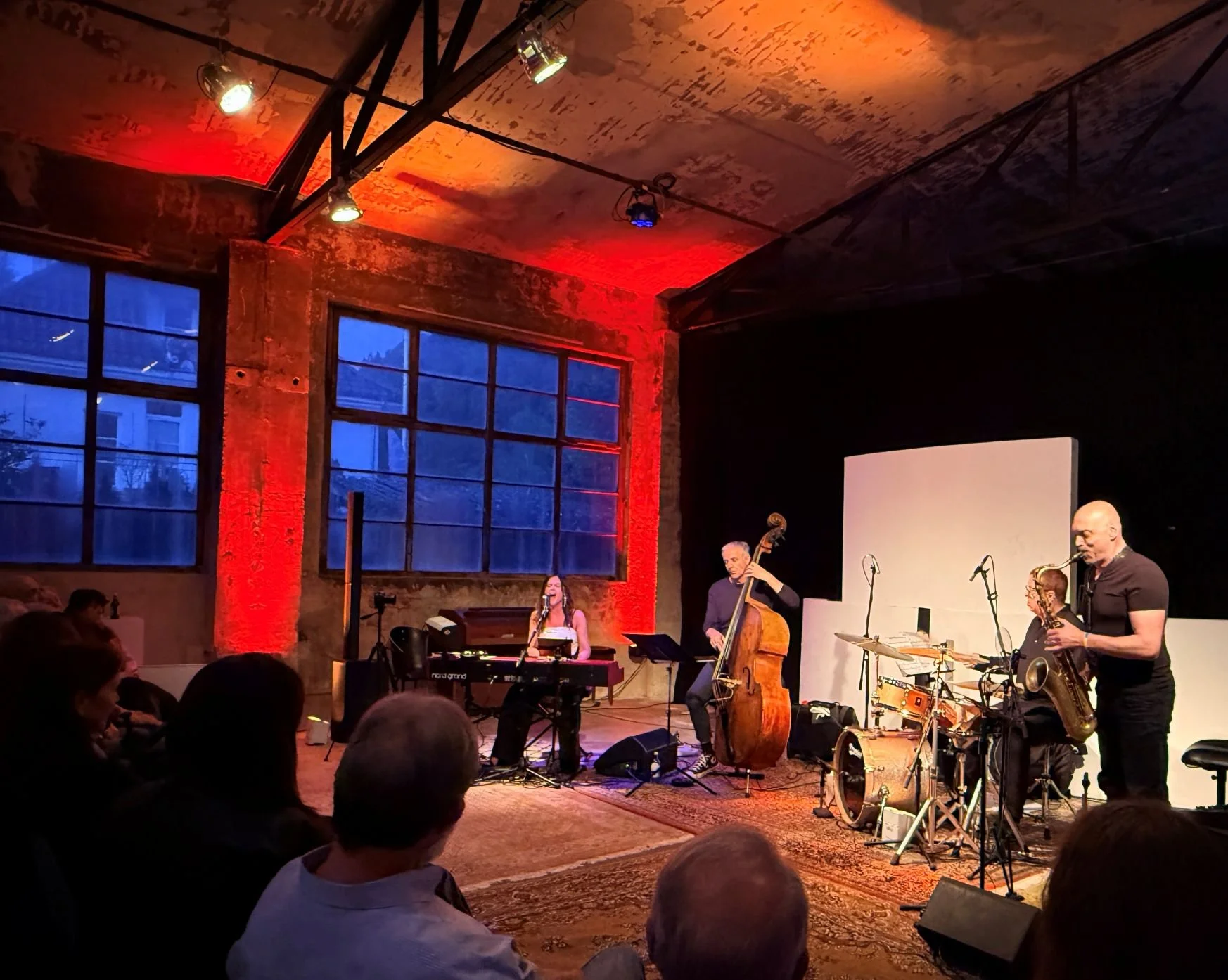 Die Band spielt vor Publikum, von links: Alona Negrich singend am Piano, German Klaiber am Kontrabass, Michael Kersting am Schlagzeug und Arno Haas spielt Saxophon