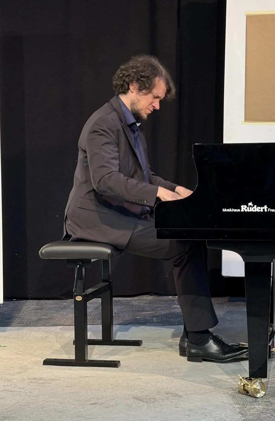 Der Pianist mit starker Mimik ins Spielen vertieft am Klavierflügel