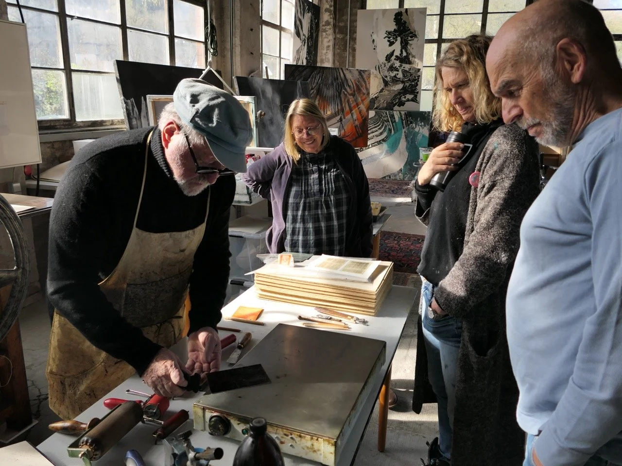 Norbert demonstriert den Interessierten das Auftragen des Hartgrunds