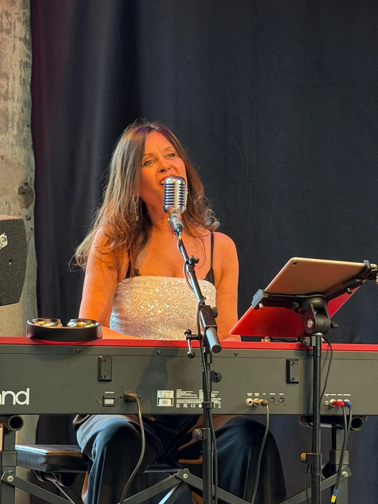 Alona wie sie am piano sitzt und singt, sie lächelt dabei