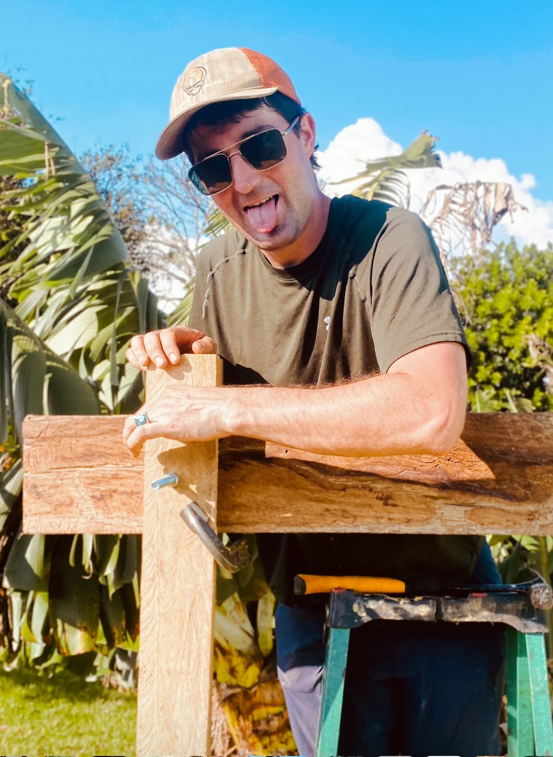 A man sticks his tongue out at the camera while working atop a ladder doing construction in Costa Rica.