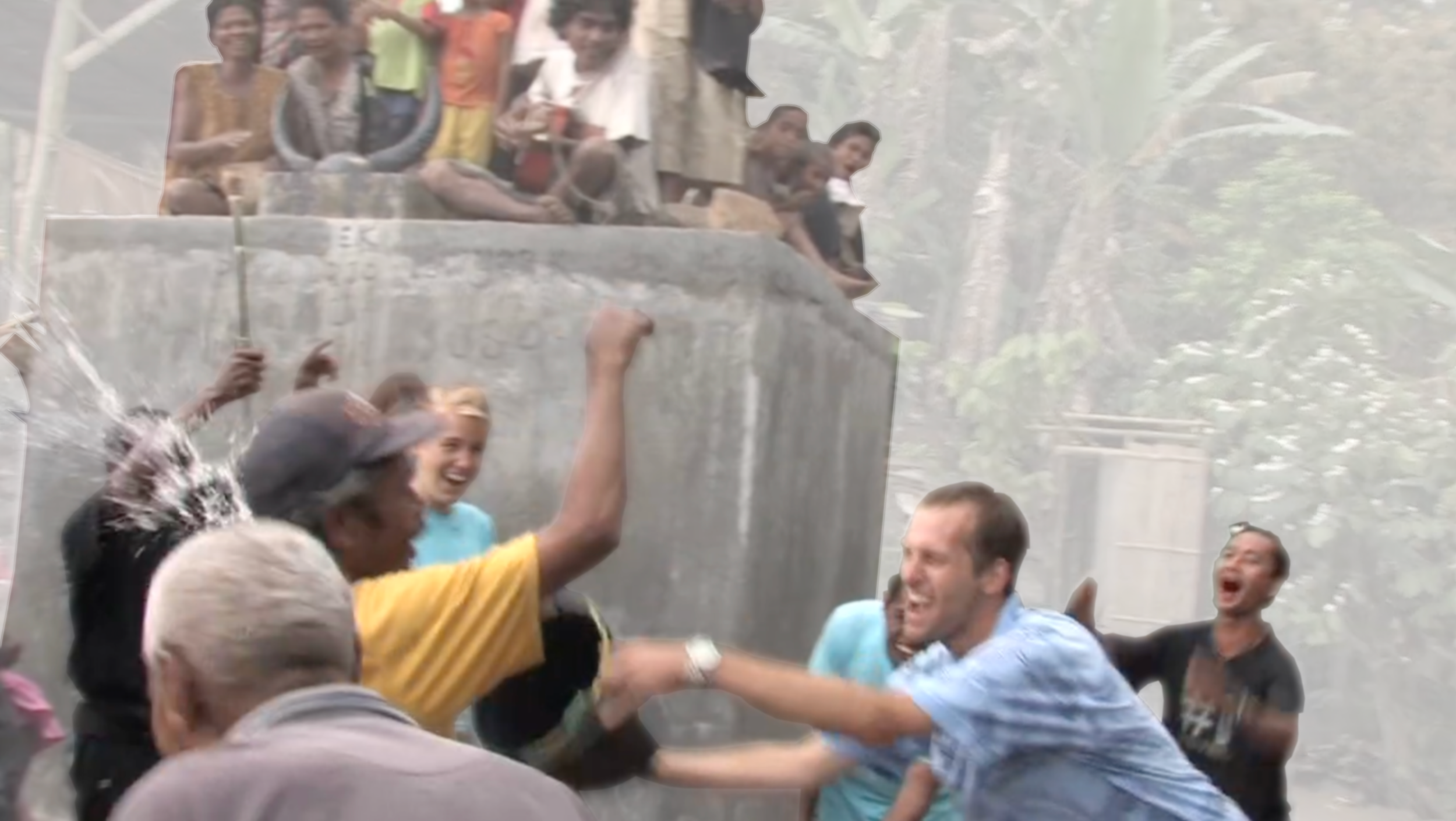 People celebrating outside, engaged in a joyful water fight or splash, with some on a raised platform and others reaching up from below.