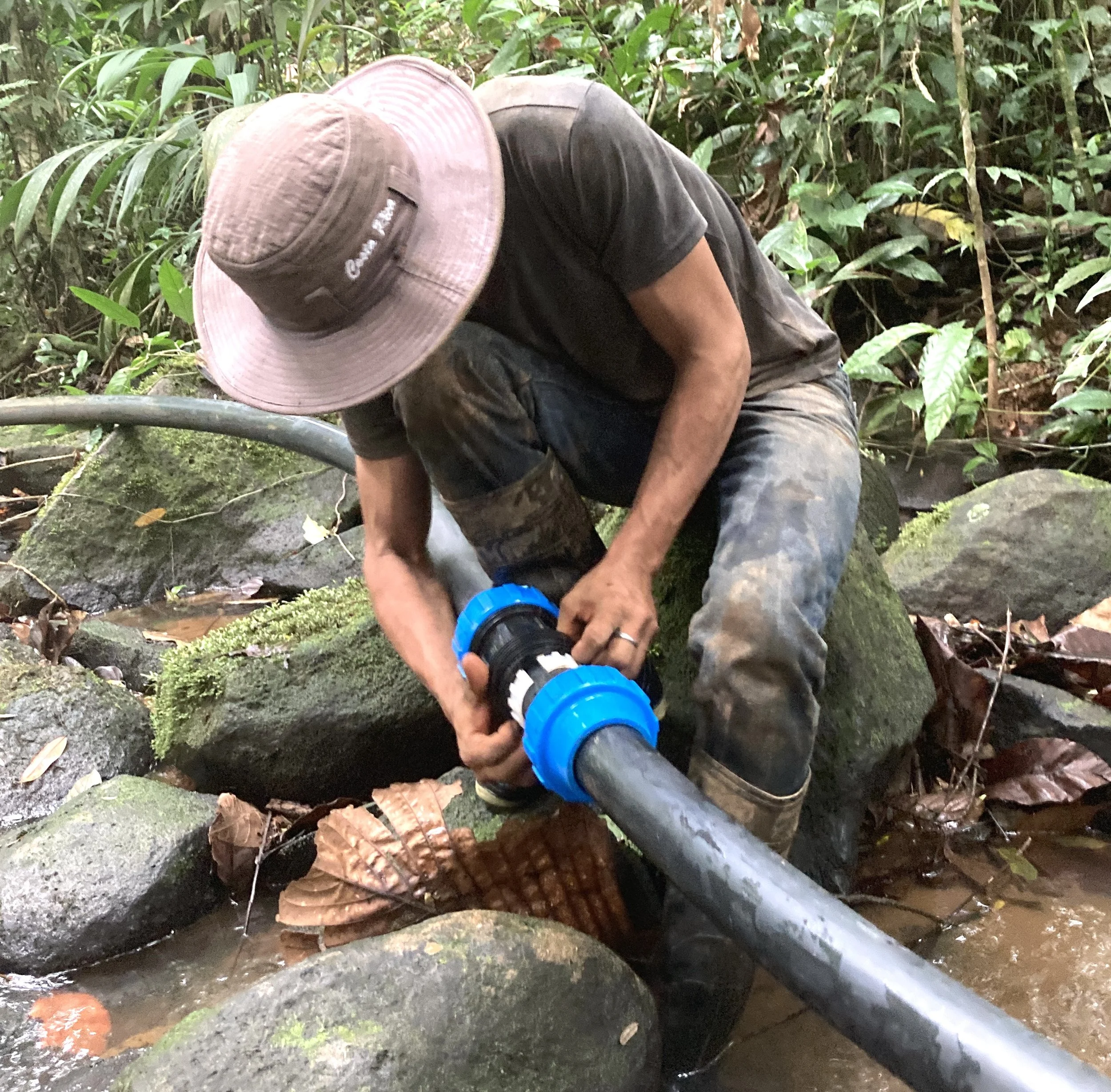 Brian tightens the connectors on 2" PVC pipe in the river bed in Costa Rica.