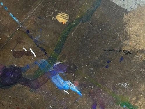 Close-up of a painted and textured surface with various colors, including blue, purple, green, black, and beige.