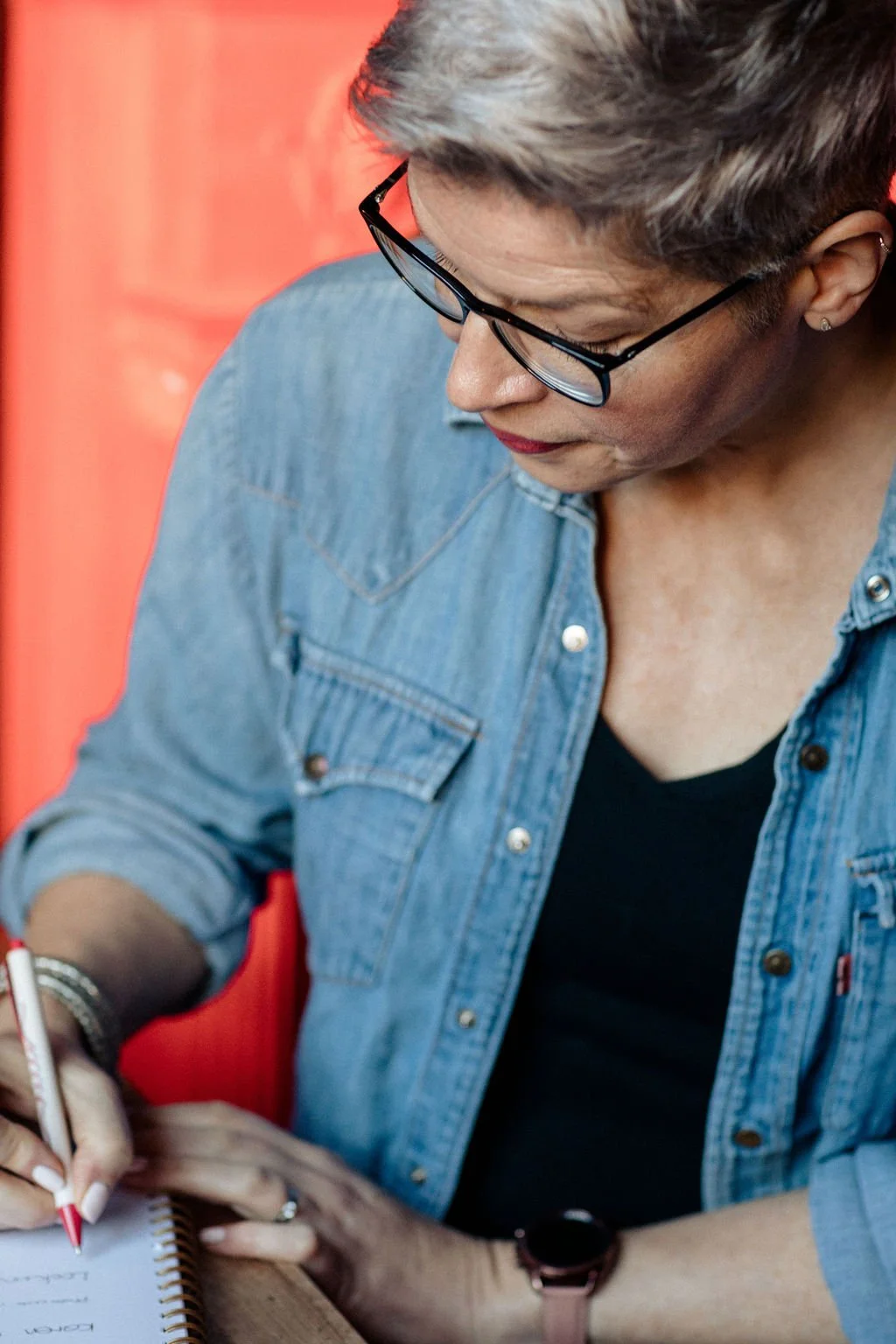 Jilly sat at a desk writing in a notebook.