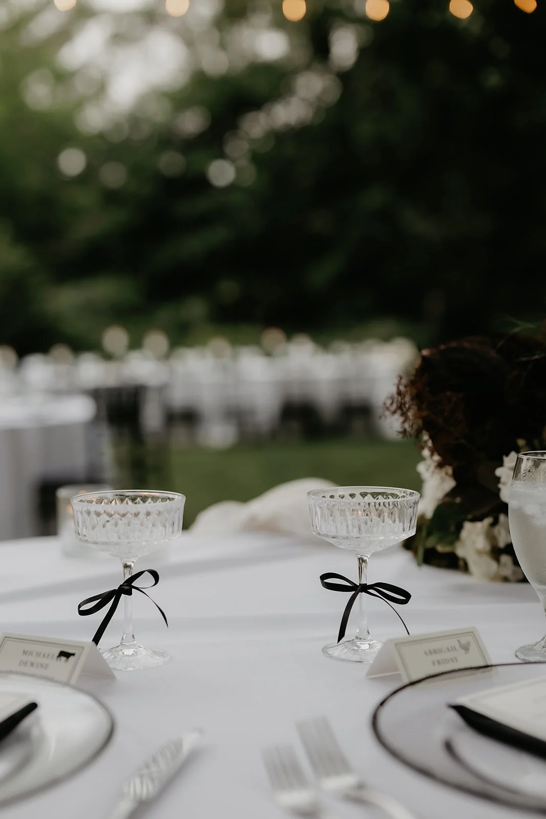 Champagne coupes with black bows on the sweetheart table