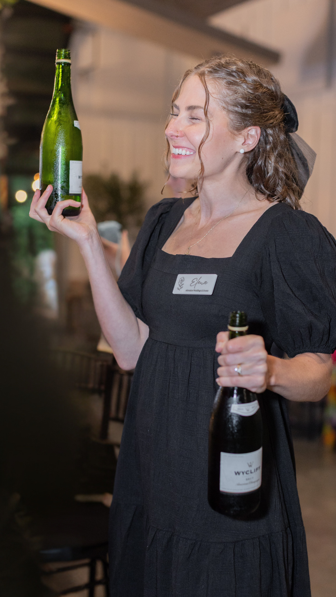 Elena Markwood, wedding planner in Columbus OH, smiles as she pours champagne for guests