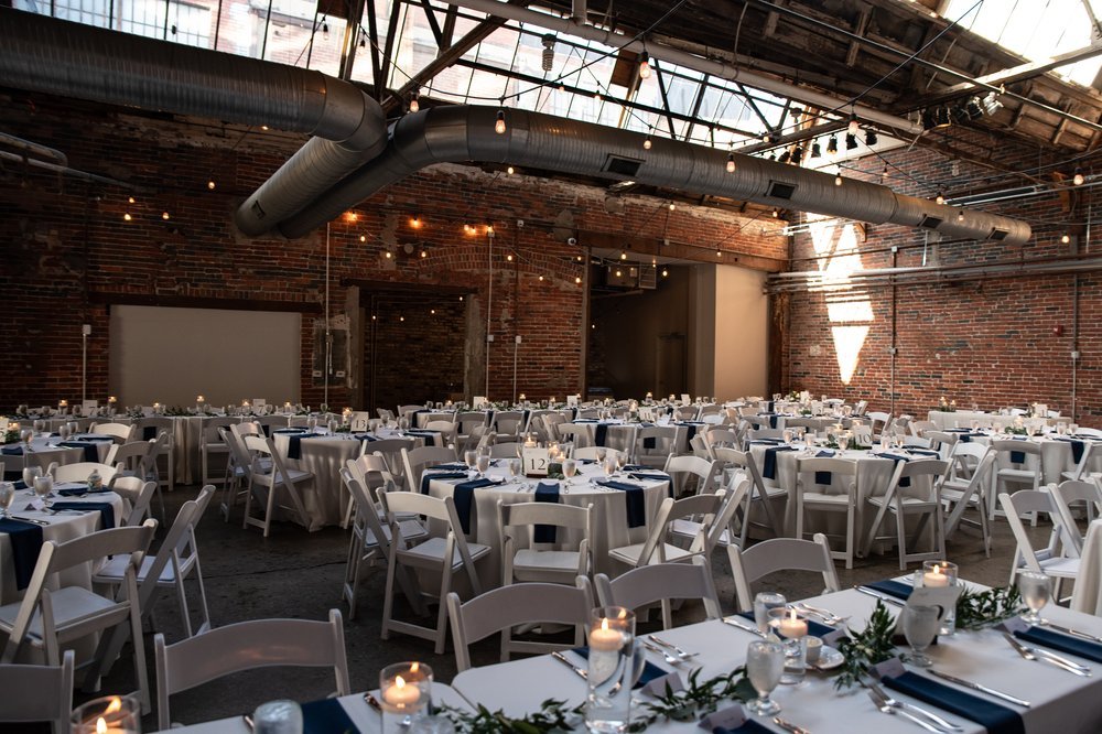Industrial reception space with candlelight and greenery