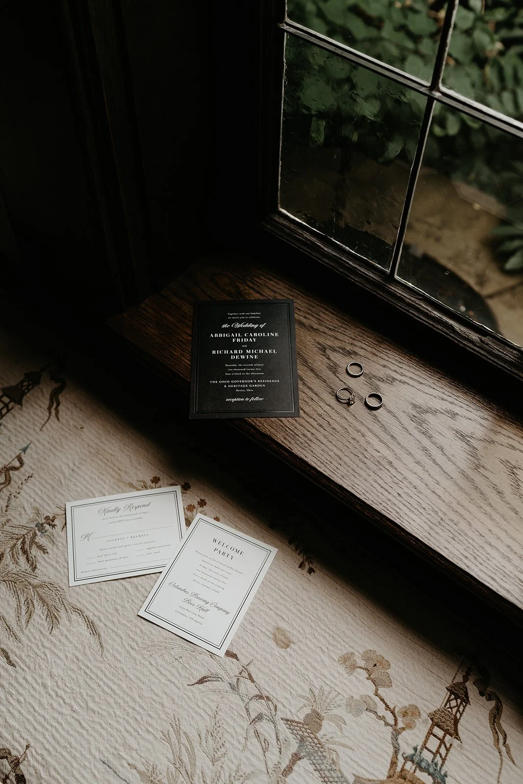 Invitations and rings laid out on a window seat