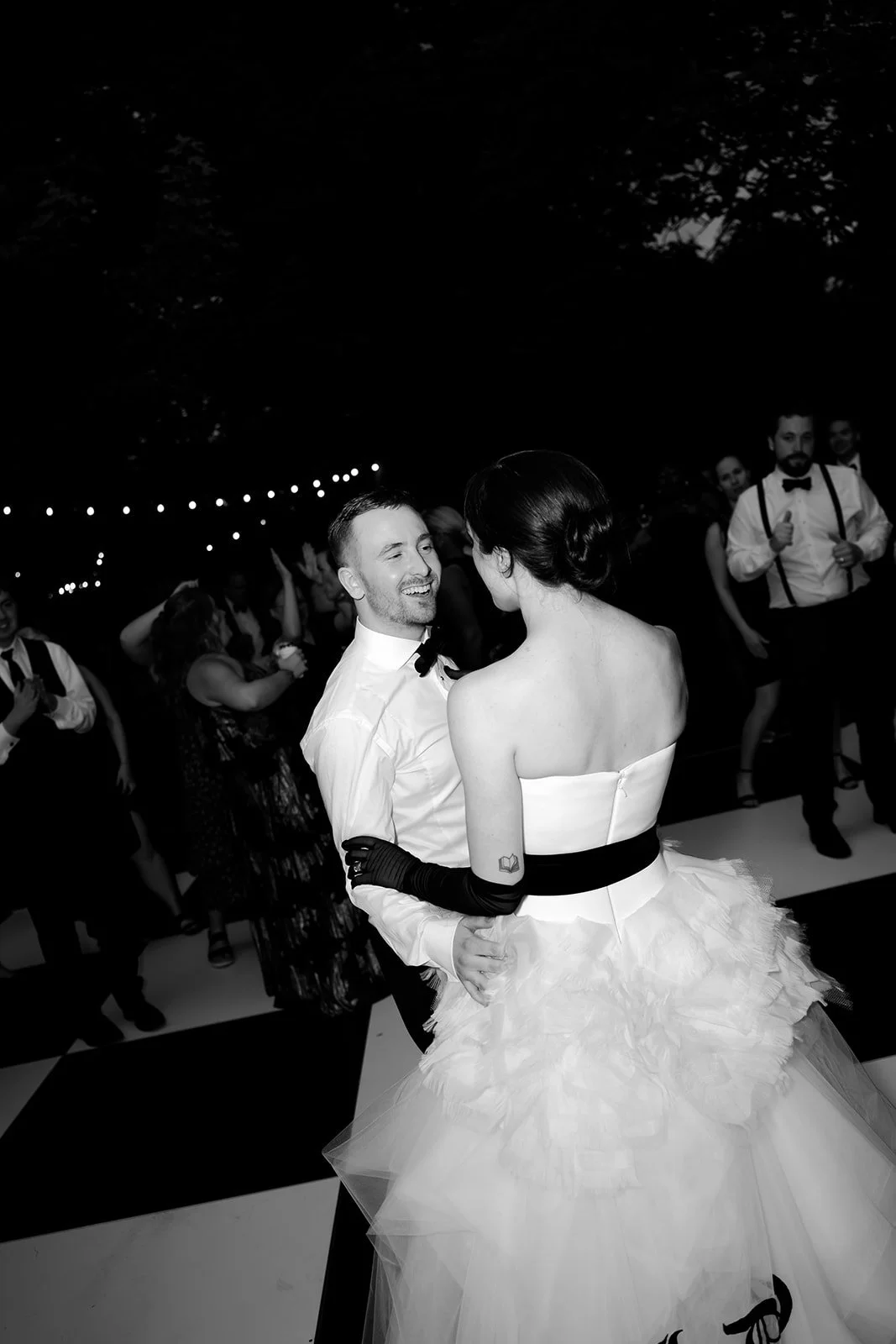 Bride and groom laugh together on the dance floor