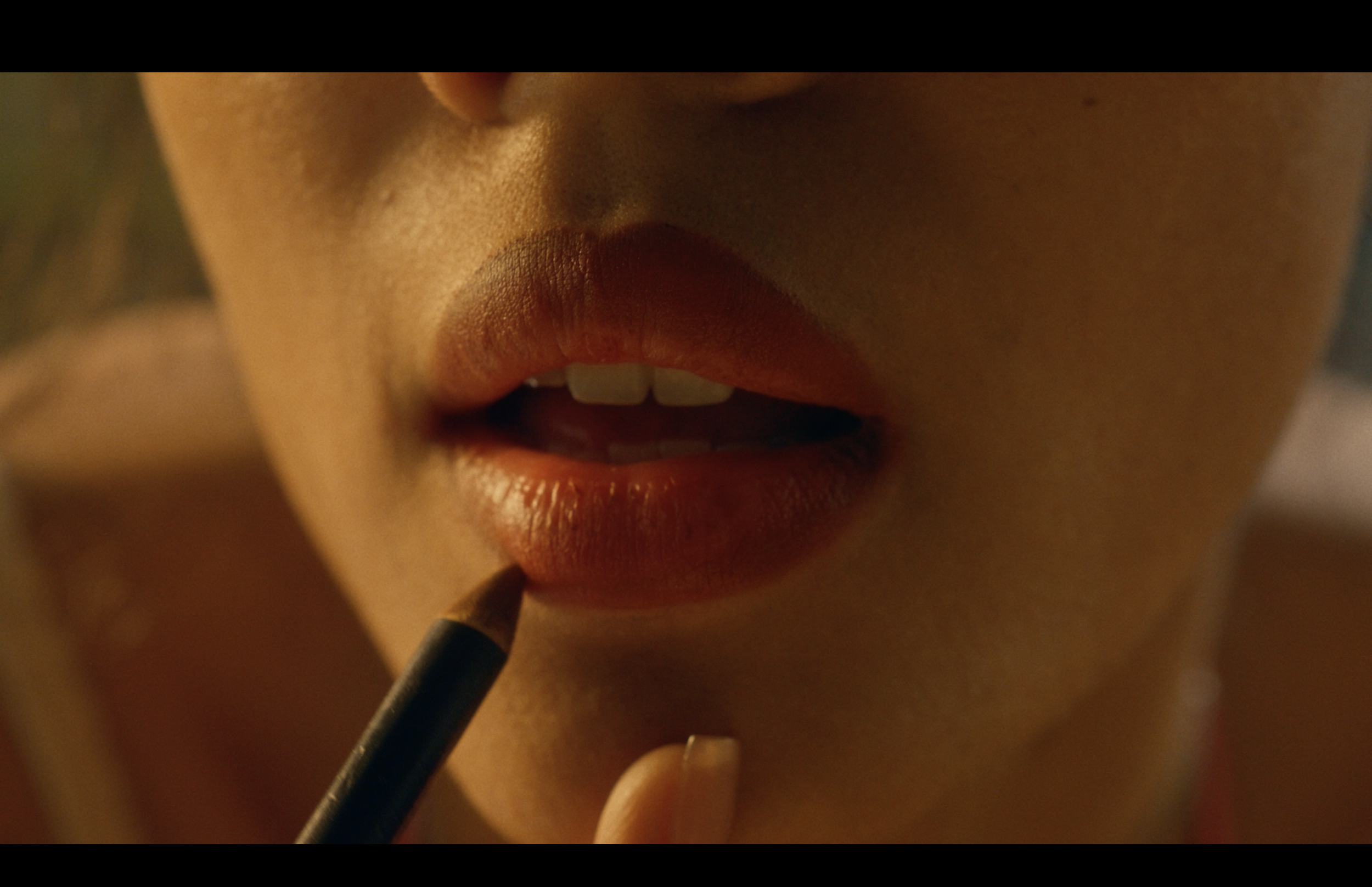 Close-up of a person's lips being painted with lipstick.