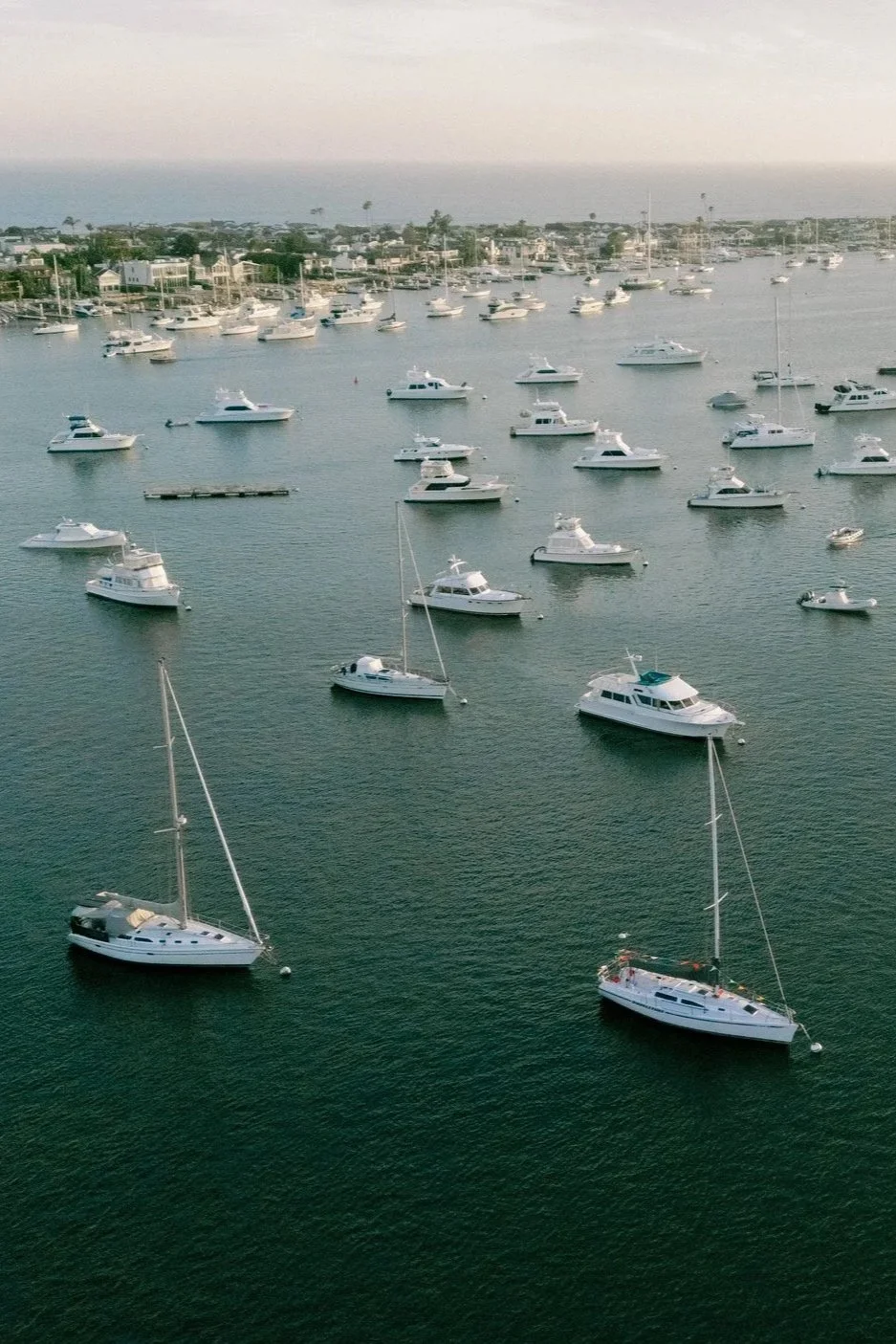 Drone Photography of the harbor and sailboats during a wedding at the balboa yacht club in Newport Beach