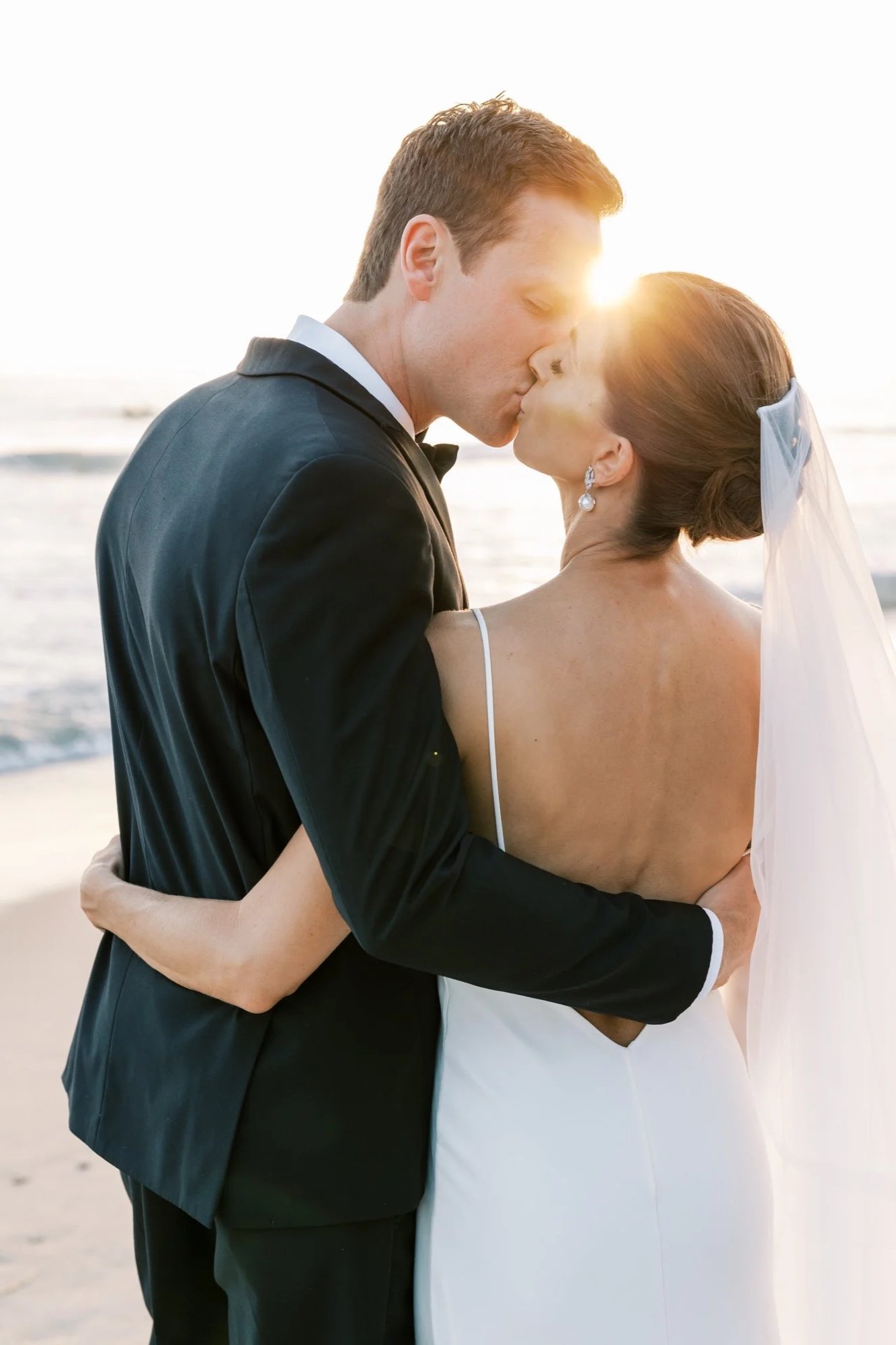 Couple kisses at sunset on the beach during a Ritz Carlton wedding in Laguna Niguel