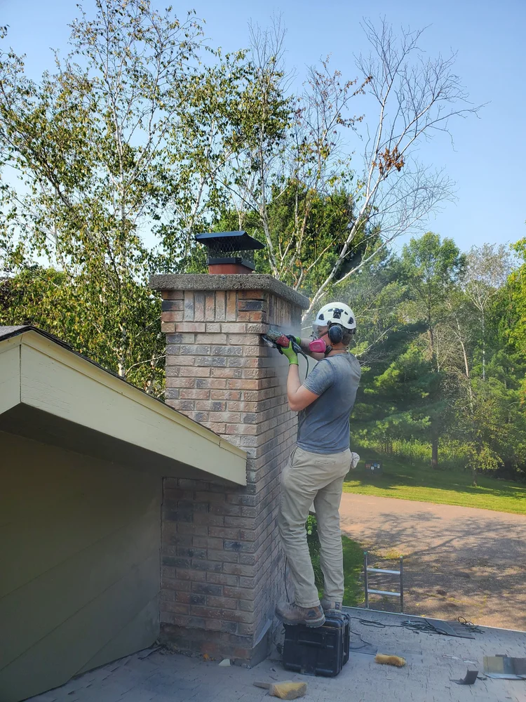 Our crew up on the roof working on a brick chimney