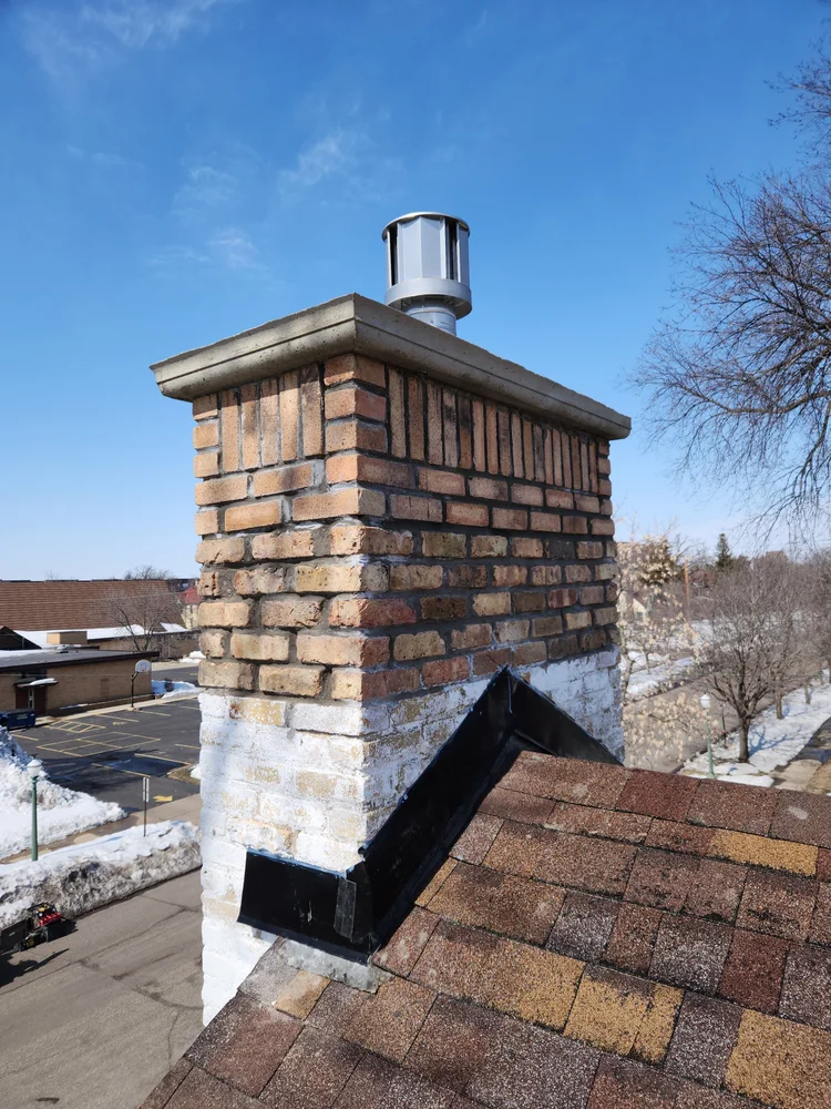New brick above the roofline and a new crown. Our own crew.