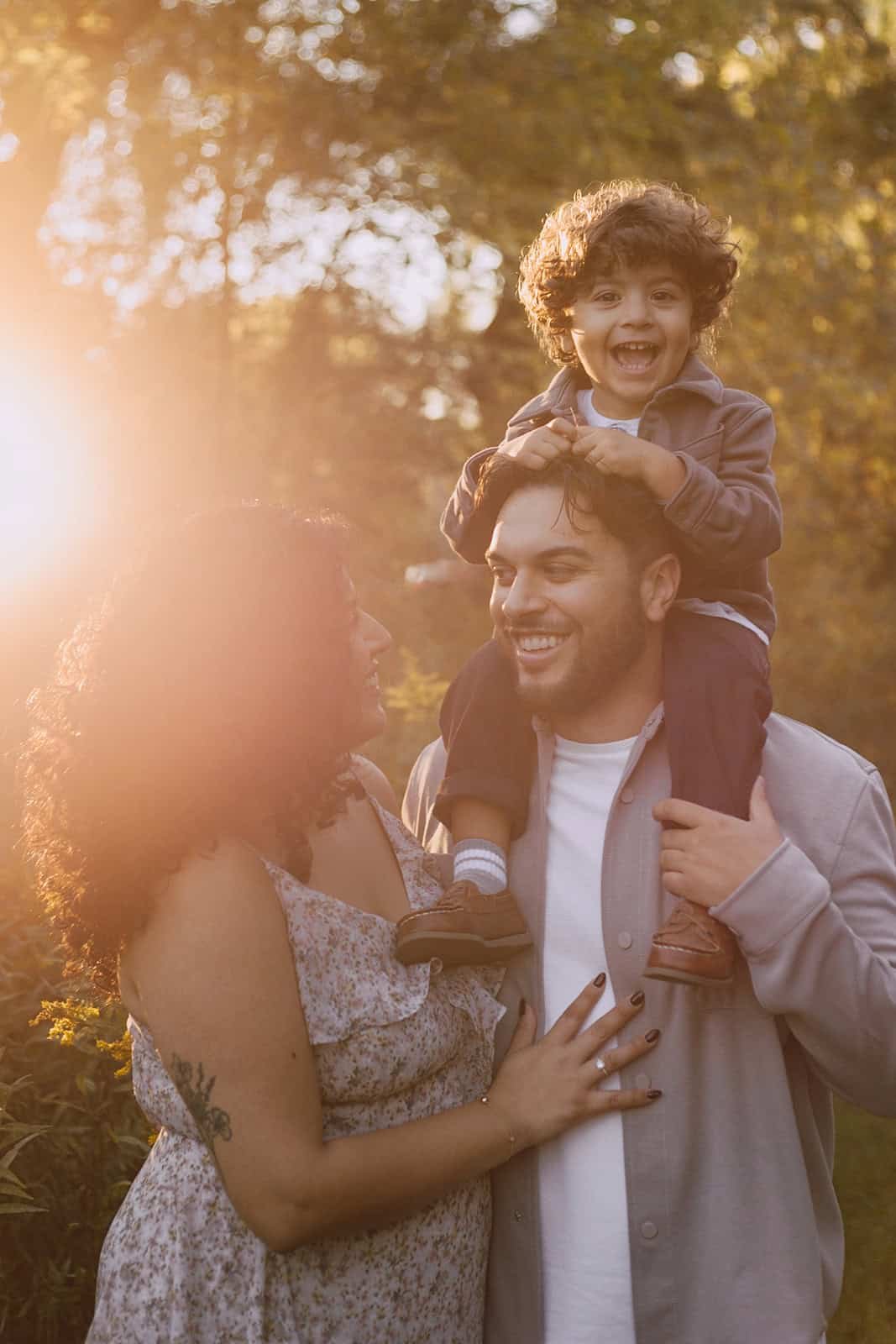Family of 3 standing in the sunset in the summer in Hamilton