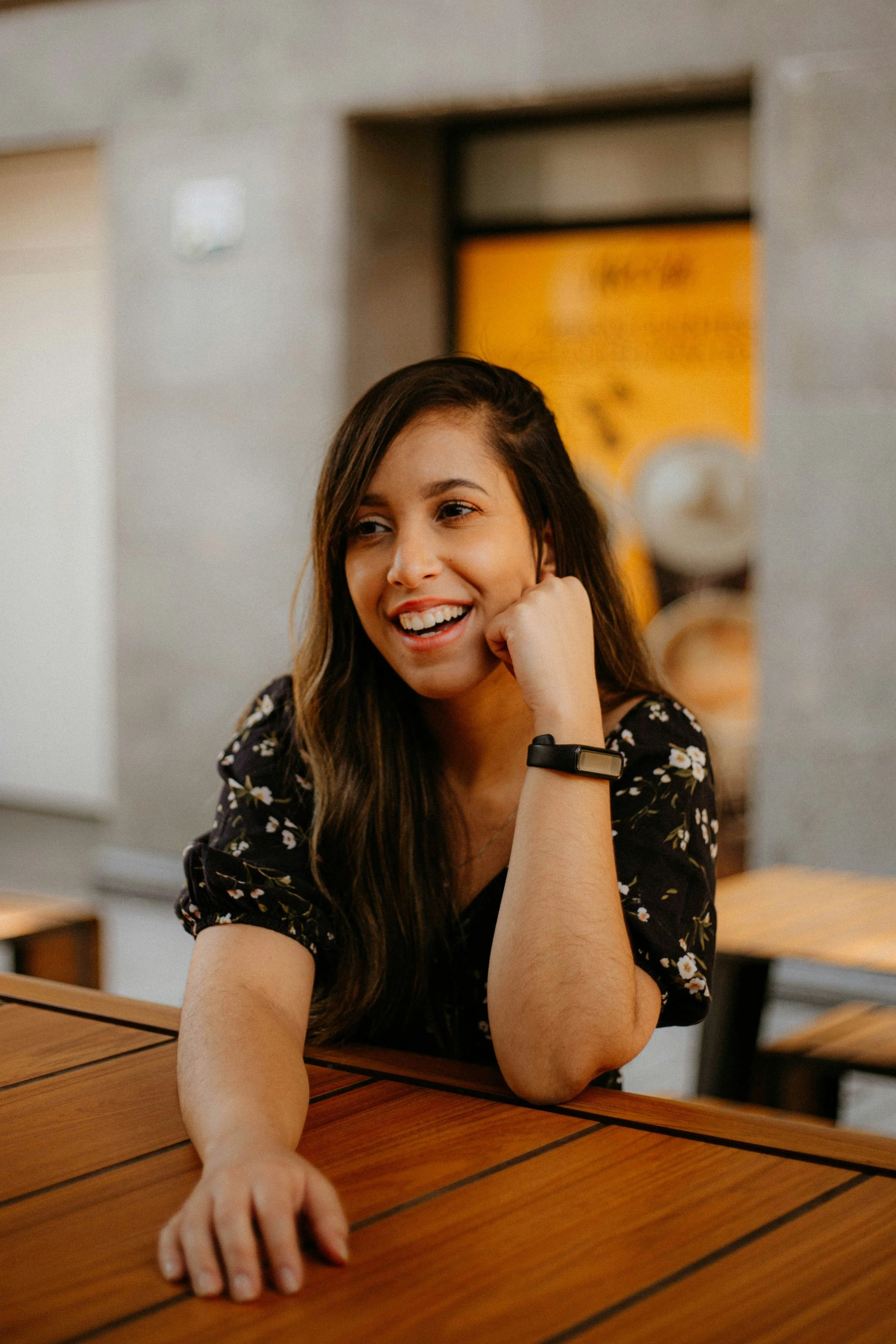 A woman is sitting at a table and smiling