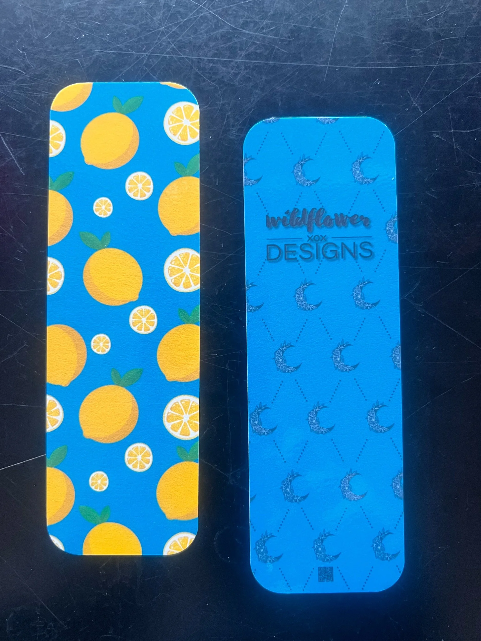 image of bookmark "lemon squeeze" on table, with two bookmarks showing the front and back of it.