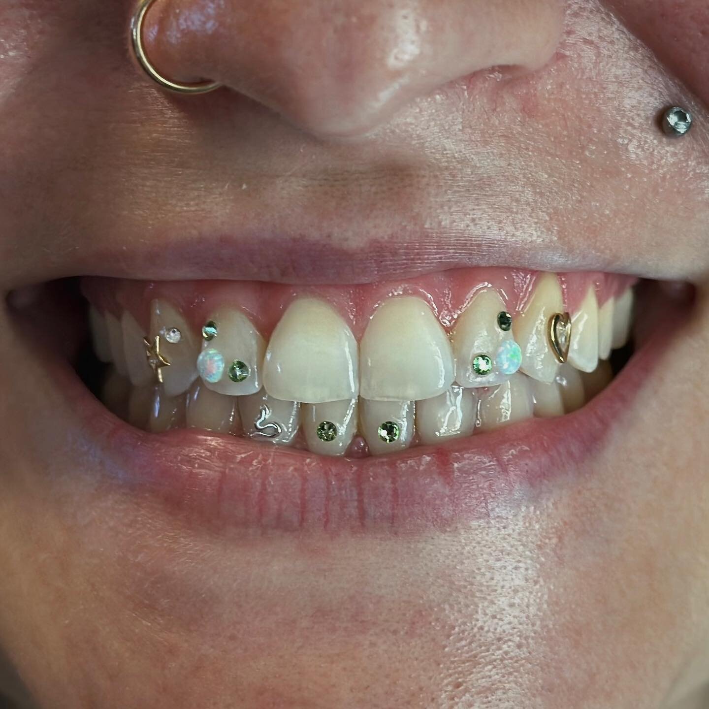 Beautiful tooth gem design freestyled together to match their necklace! Gold tooth gems from @sparklebymaya 🪄✨
.
Spooky Tooth Gems for Halloween are a must! Blood, bats, pumpkins, we&rsquo;ve got it all. Schedule online 🎃
.
.
.
#toothgems #seattle 