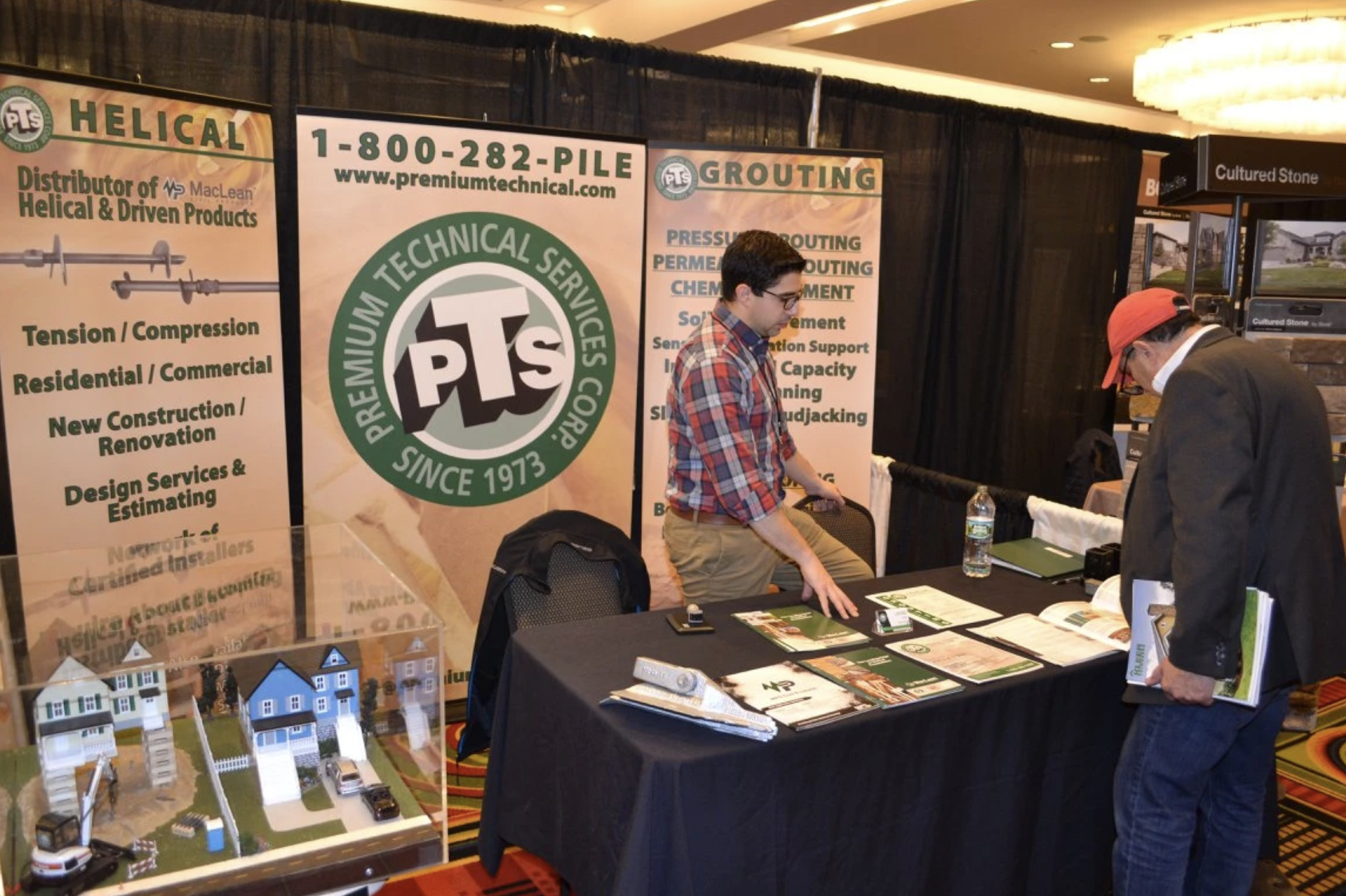  Two people talking at booth at the AIA Annual Product Fair 