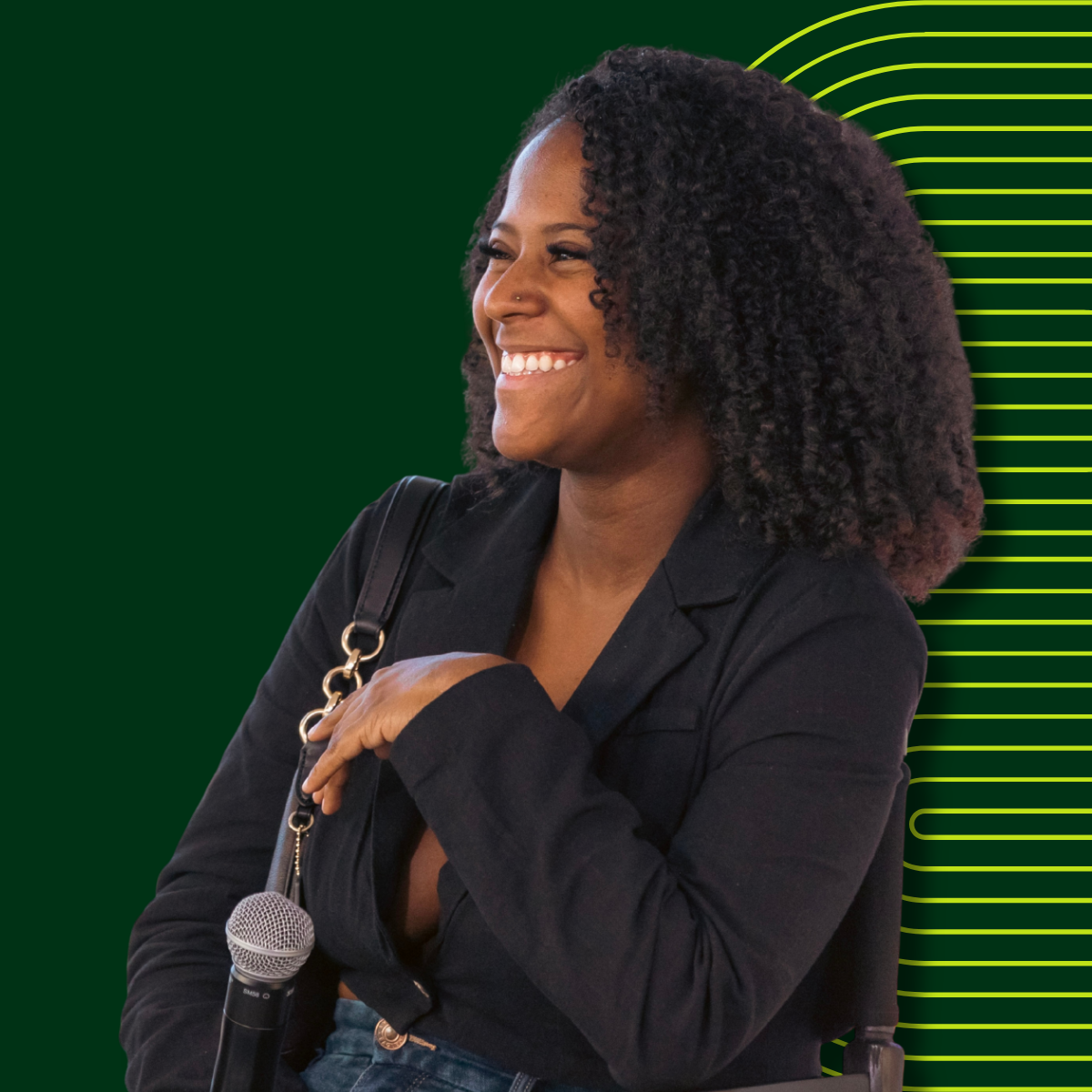 A smiling woman with short hair, wearing a shiny, copper-colored blouse, sitting in front of yellow curtains.
