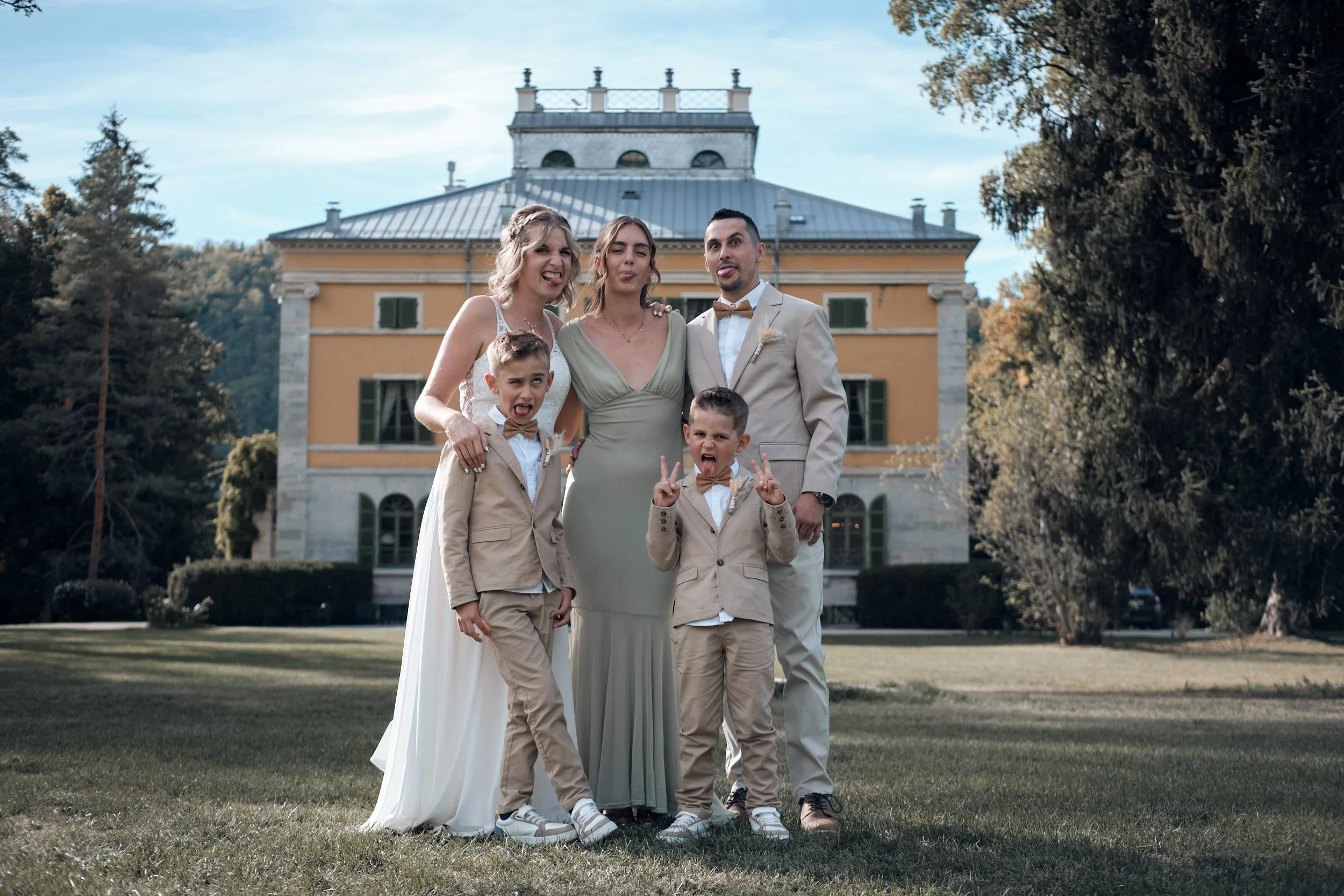 Photo de groupe avec les mariés deux enfants et une témoin devant la villa palladienne au Château de Syam pour leur photo de groupe