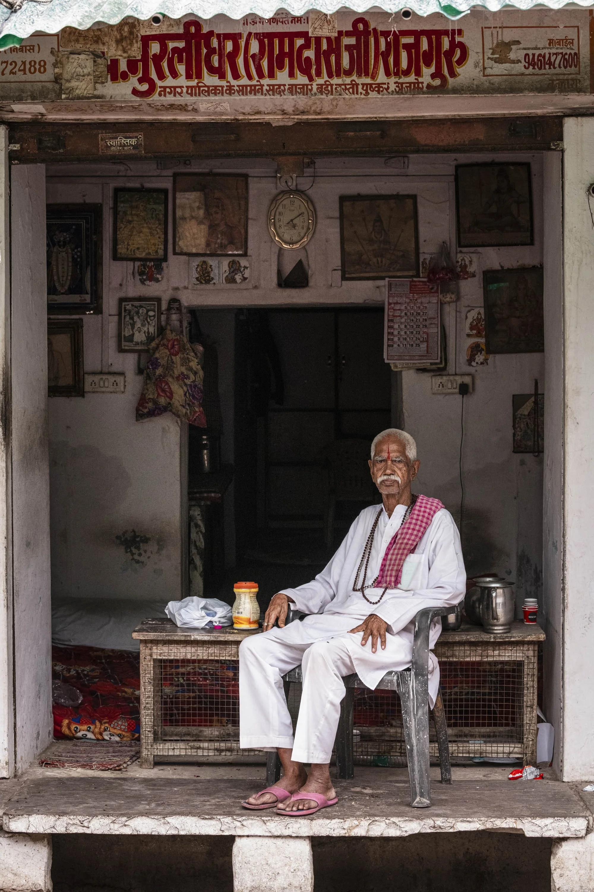 Old man seated at his shop entrance in Pushkar