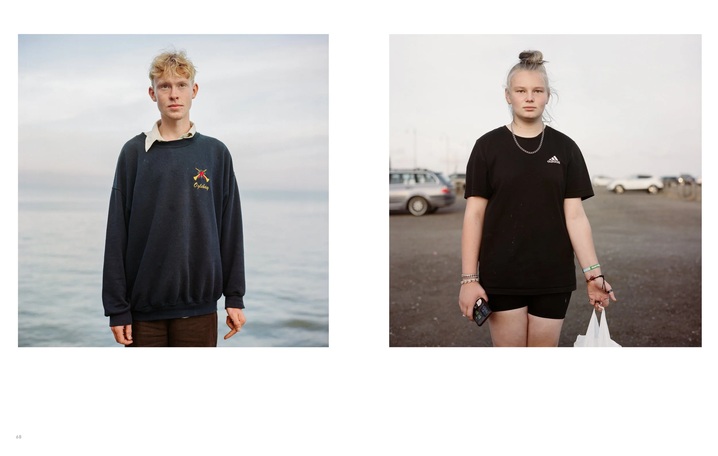 Two young individuals standing outdoors, facing the camera. The male on the left has light-colored hair and is wearing a dark sweatshirt over a collared shirt. The female on the right has light-colored hair in a bun and is wearing a black t-shirt wit