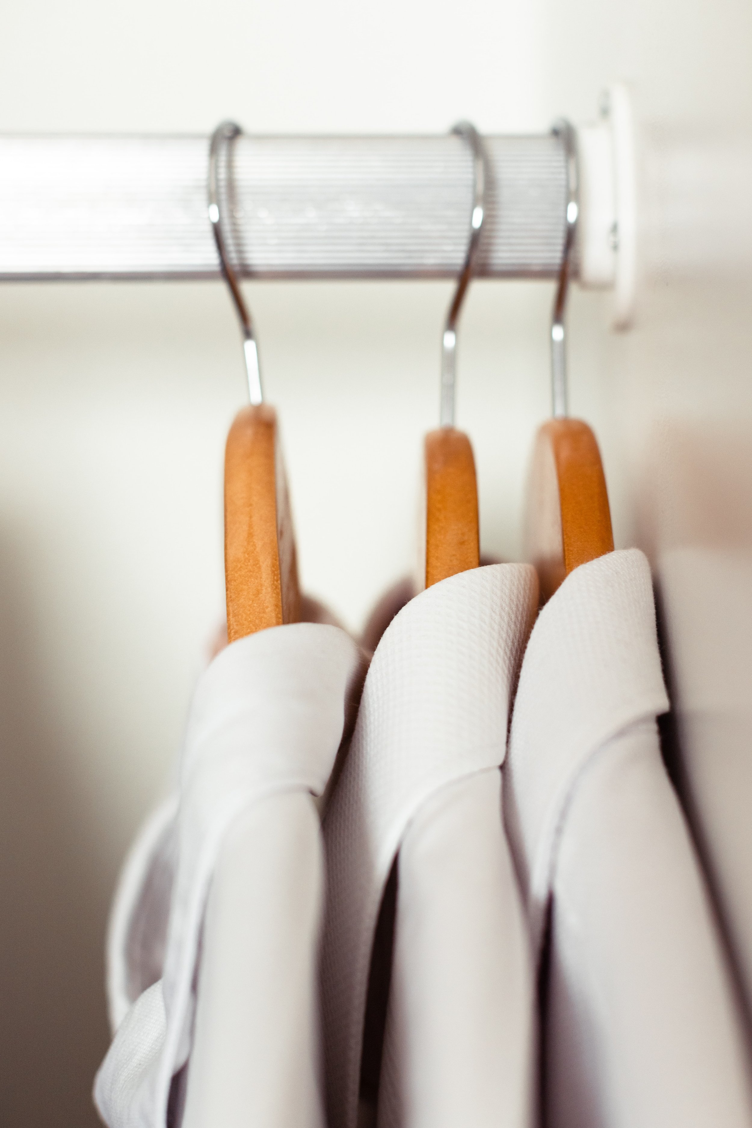 white shirts on wooden hangers