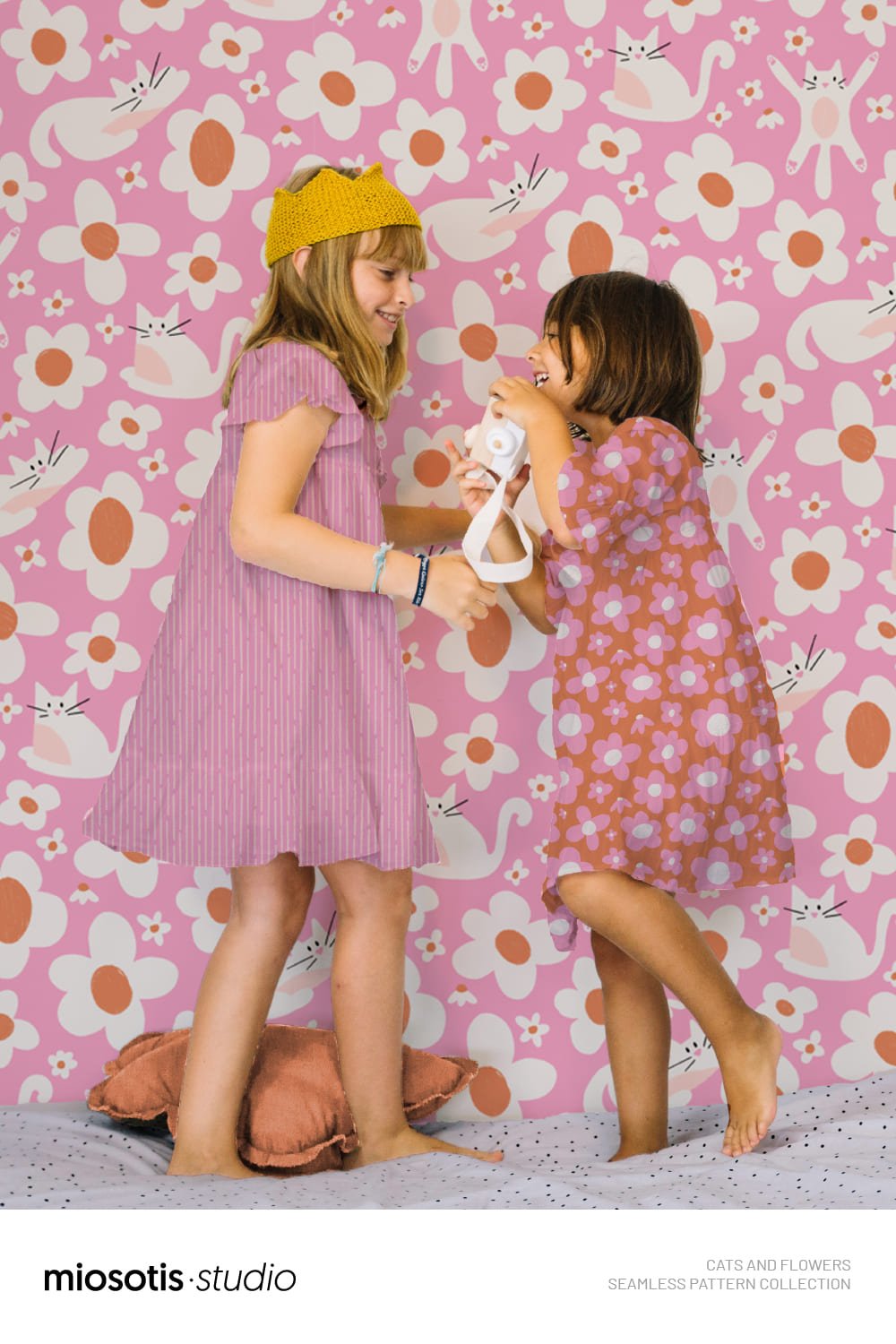 Two children wearing colourful dresses featuring the cats and flowers seamless pattern collection.