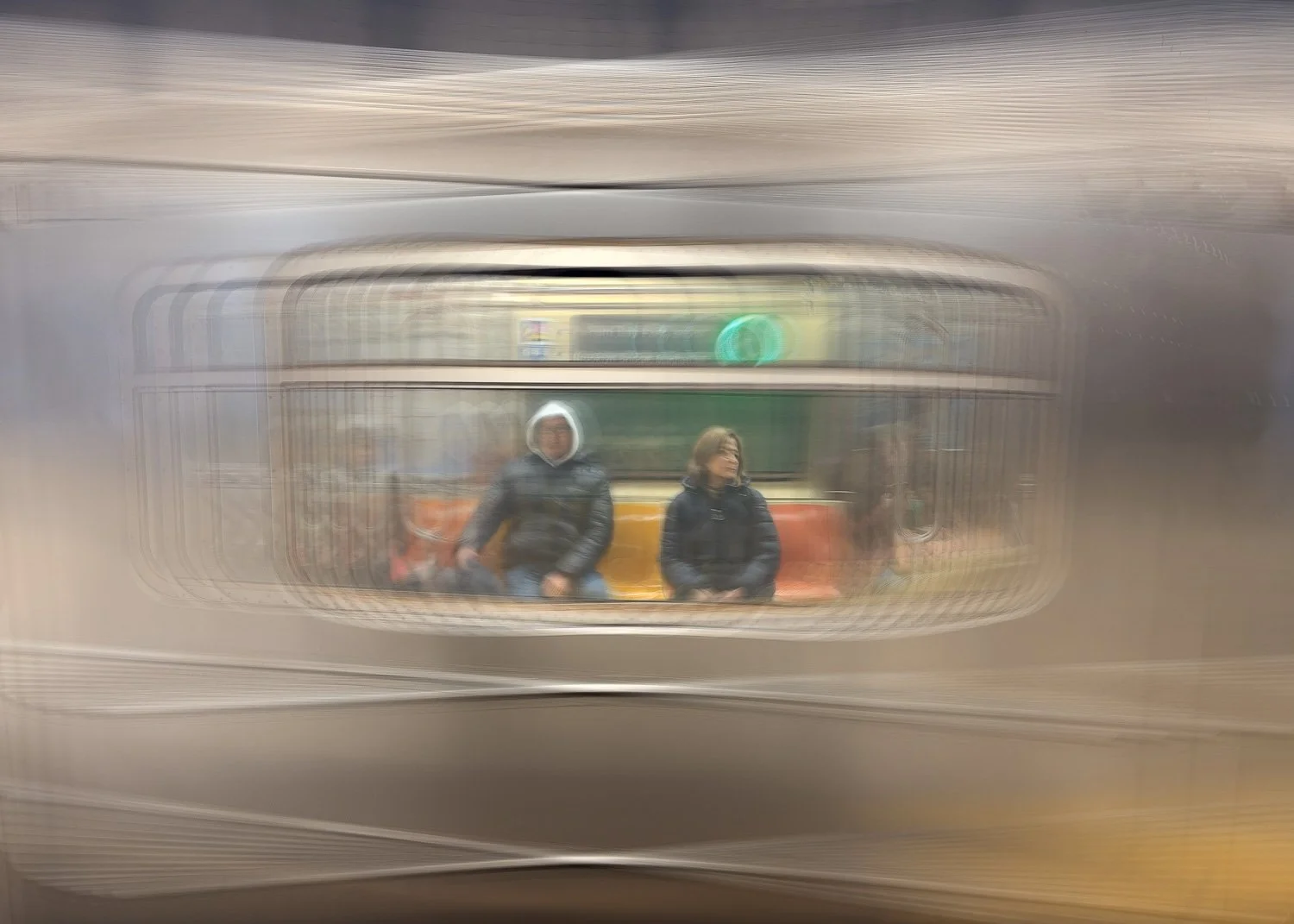 Abstract ICM Bluristic  photo - Two people sitting on a train as it enters a subway station, reflected in a moving vehicle window.