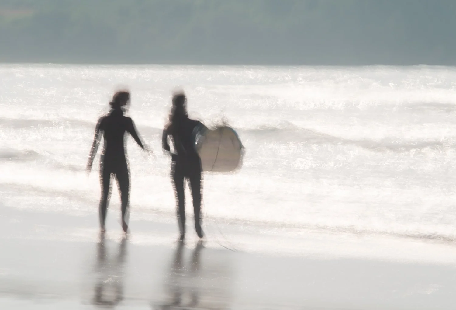 Abstract ICM image of two girls about to enter the ocean to surf.f