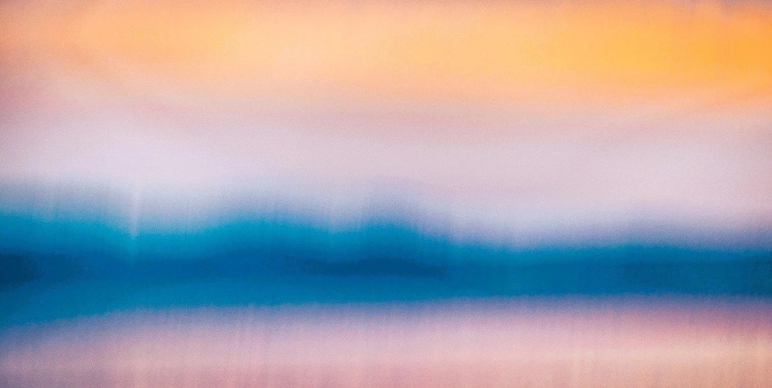 Abstract ICM image of sunset over lake and land mass