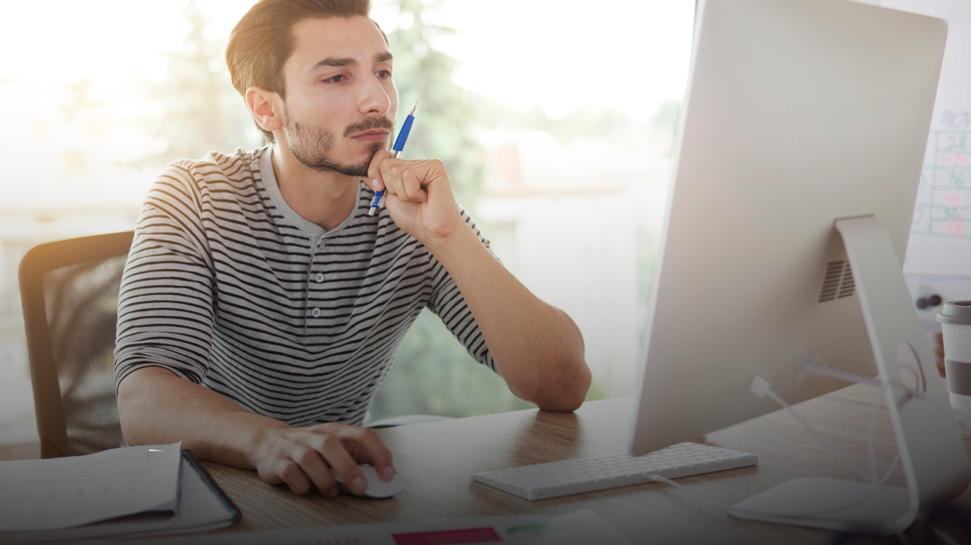 Researcher at a desk thinking at his computer — representing the research computing gap Computing for Humanity exists to close.