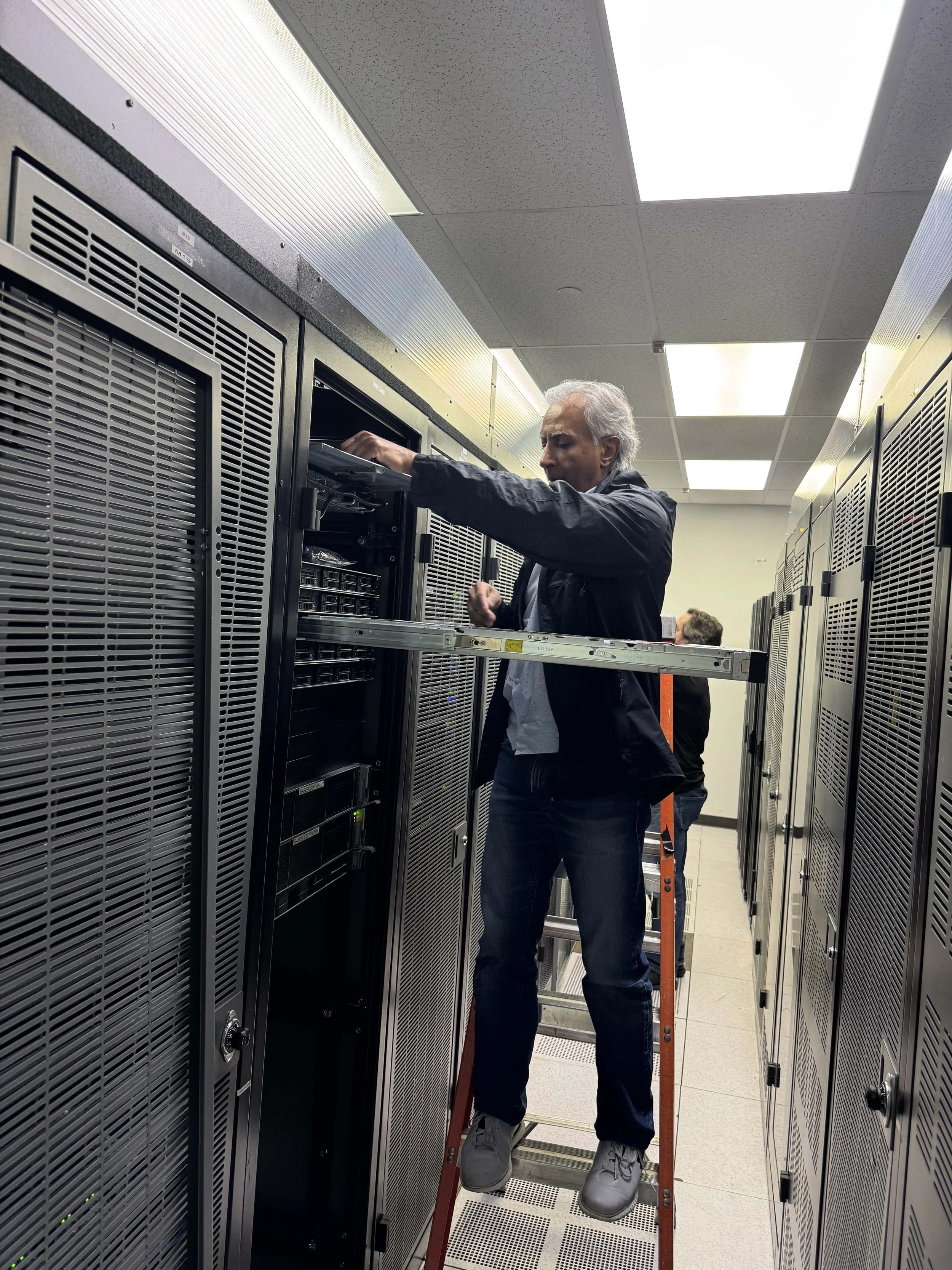 Technician installing a server in a data centre rack, part of Computing for Humanity's donated infrastructure.