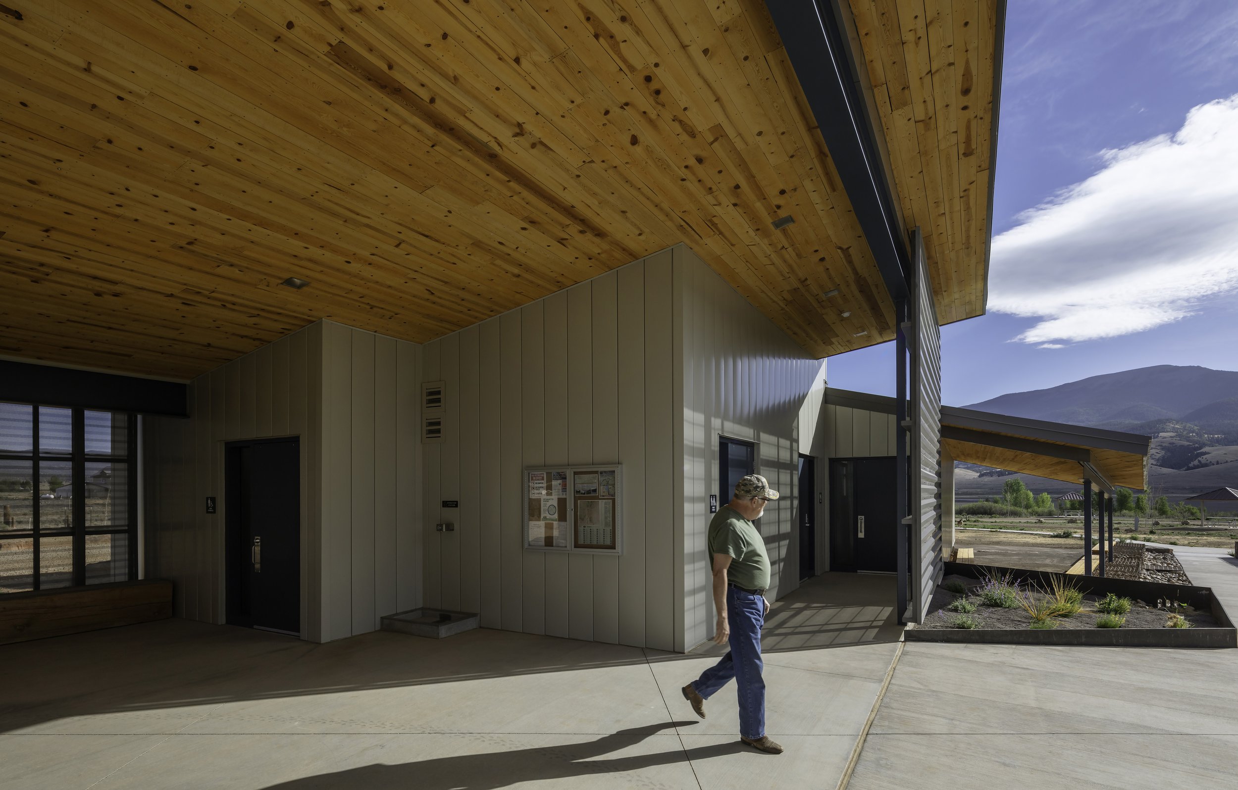 Man walking though modern wood-clad breezewaykill pine