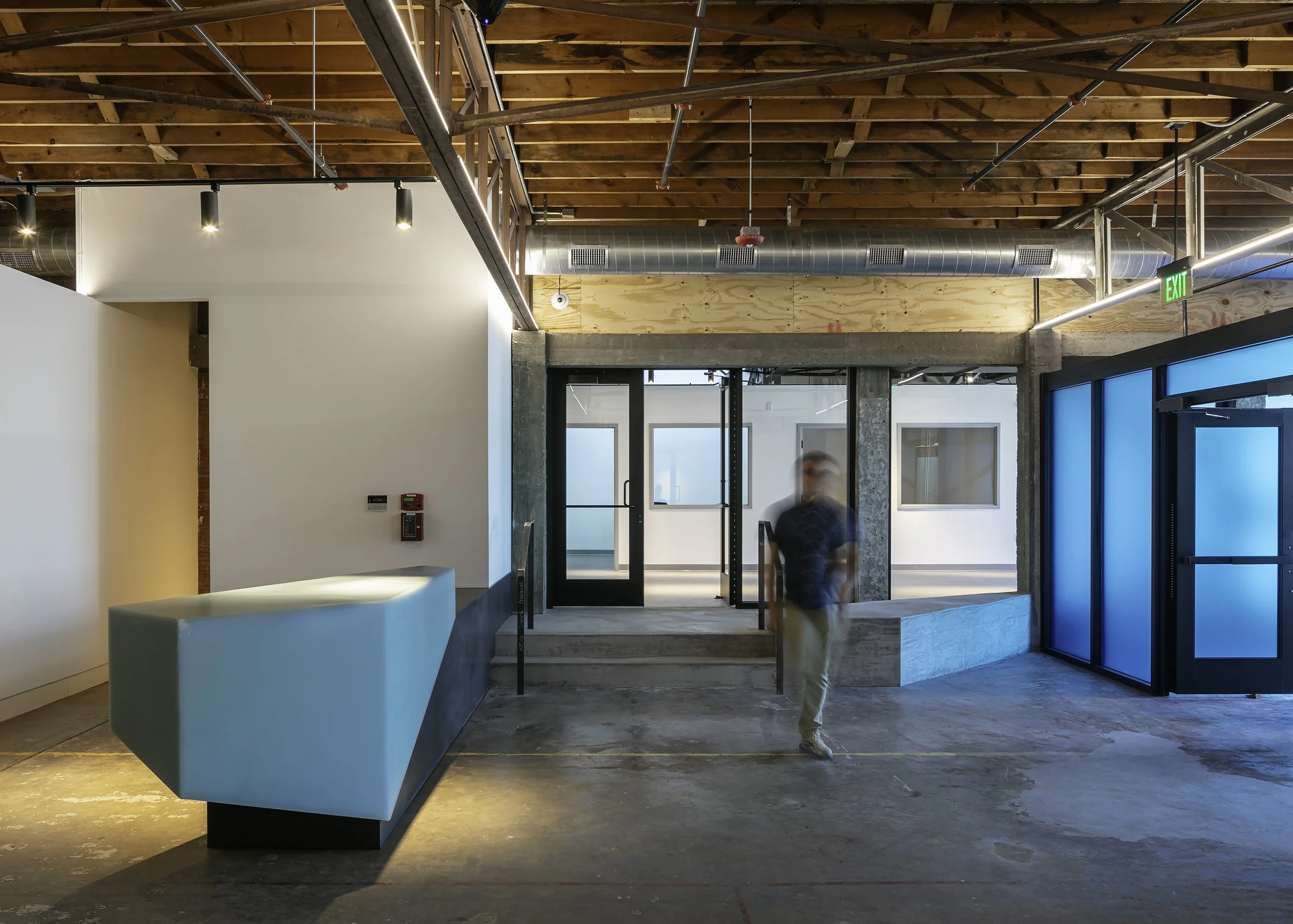Visitor walking through gallery lobby with ice block-inspired entrance and reception desk