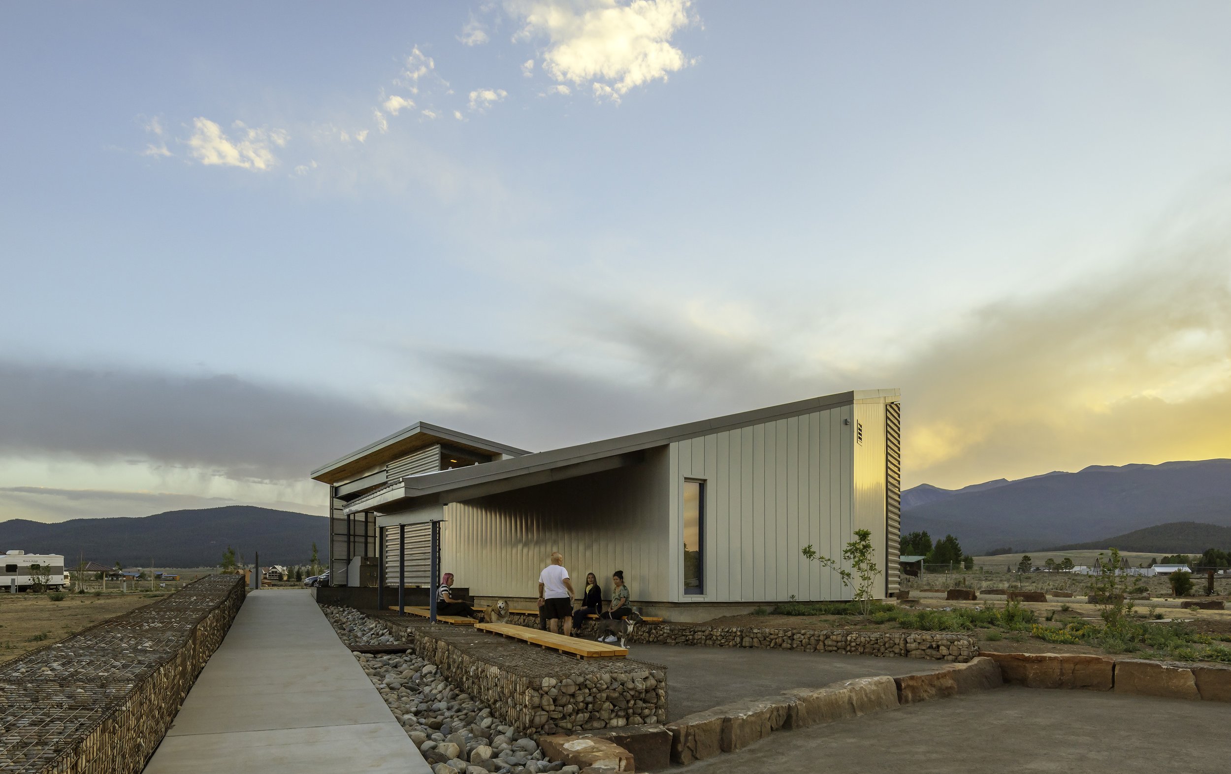 View of campers sitting under covered outdoor area with fire to be protected from the elements