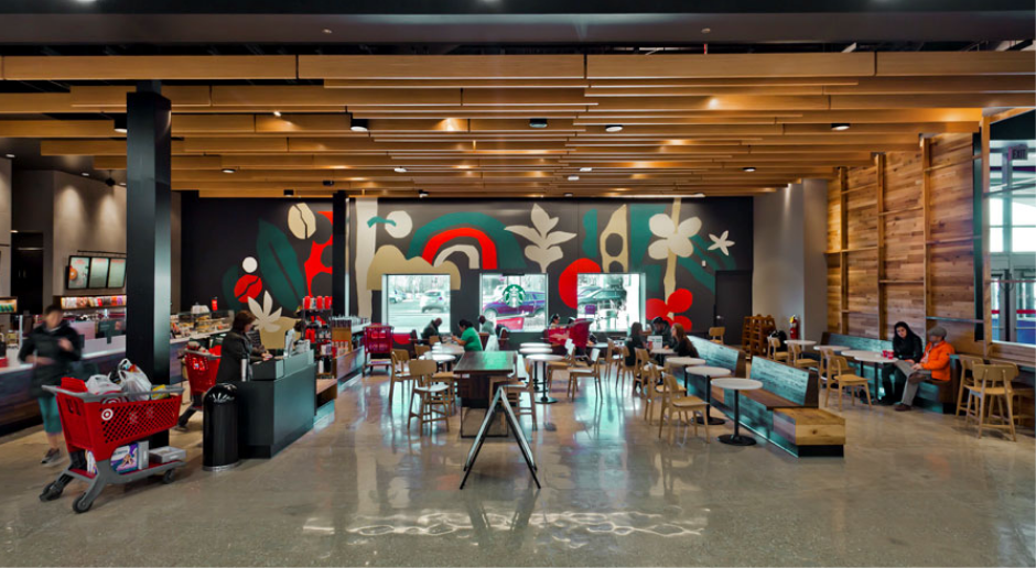 Interior of a Starbucks coffee shop with seating, customers, and a colorful wall mural