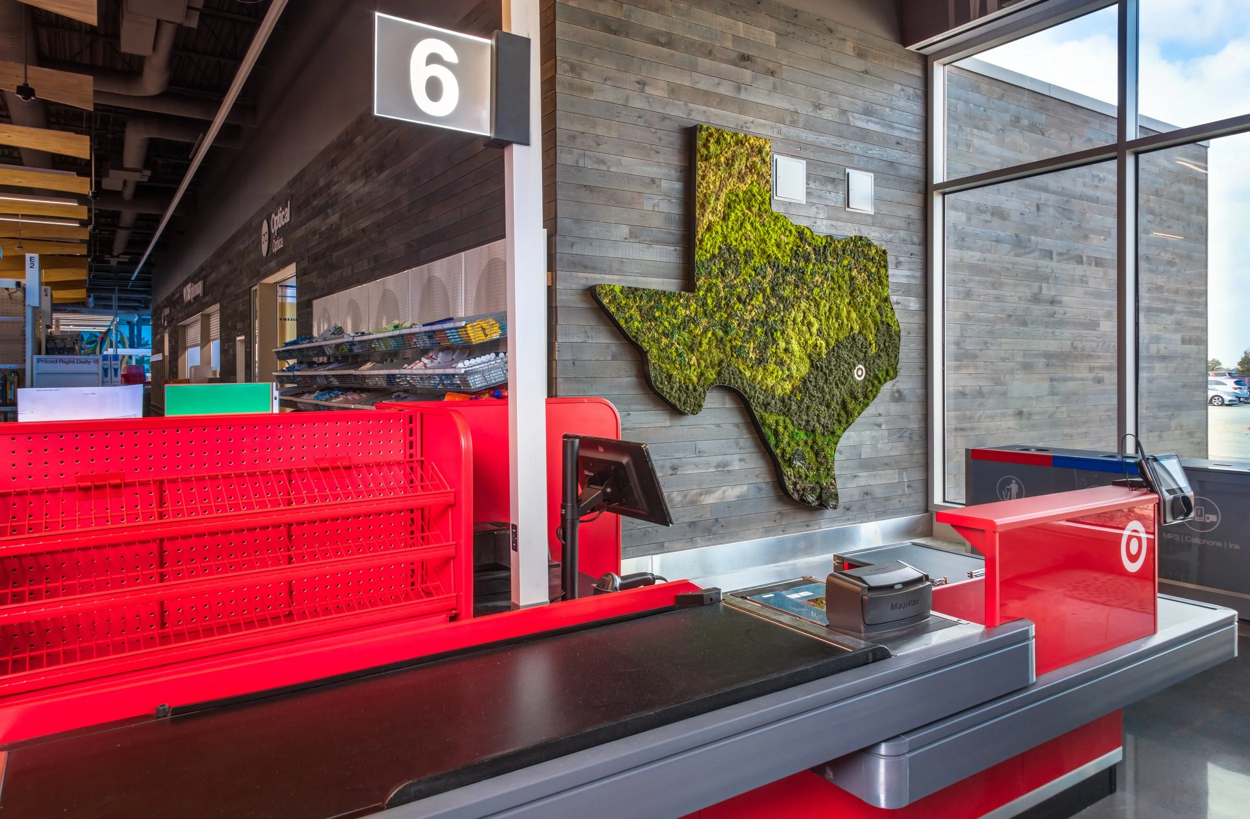 Target checkout counter in a store with a map of Texas on the wall, made of green moss and plants.
