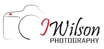 Logo featuring a stylized camera outline with a red dot for a shutter button, and the text 'J Wilson Photography' in black and red.