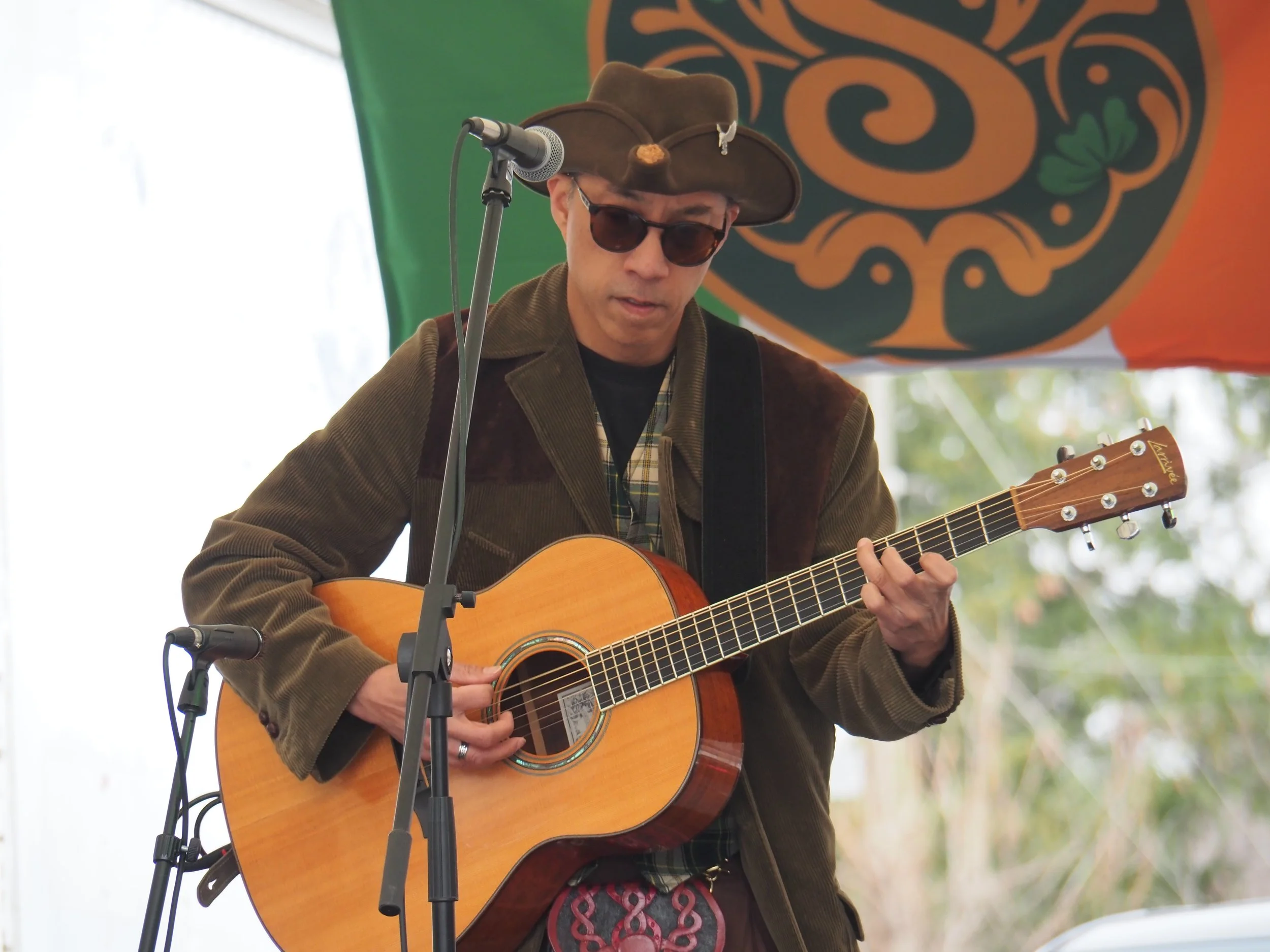 Man playing guitar on stage at Snug St. Patrick's Day 2025