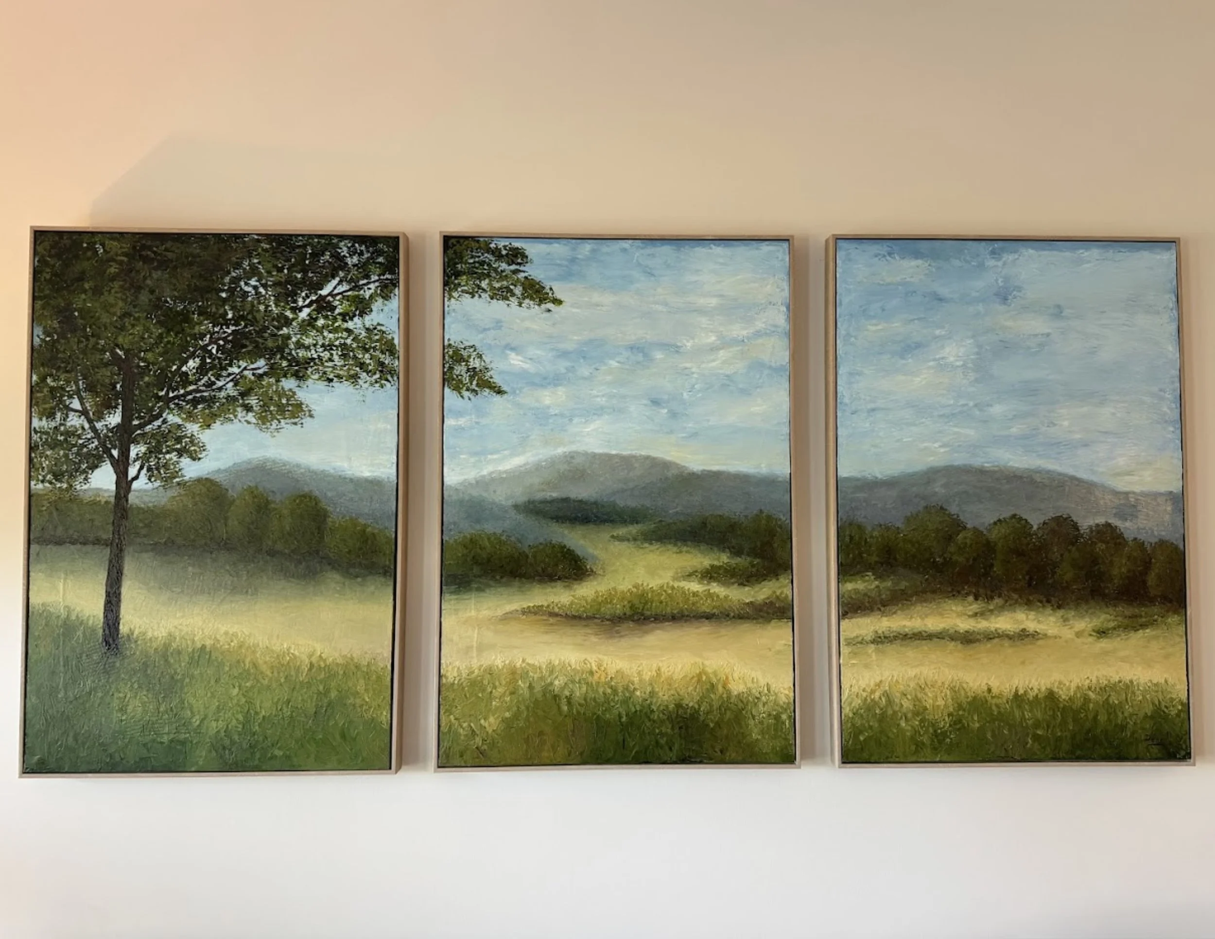 A custom triptych oil painting in soft greens and neutral tans. The large tree to the left holds personal meaning for the homeowner, making this piece the heart of the family room in this Hatfield, PA renovation.