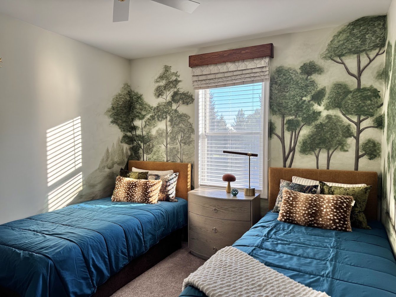 Twin beds with deep teal bedding and cognac headboards, a cozy retreat for grandkids and adults alike.