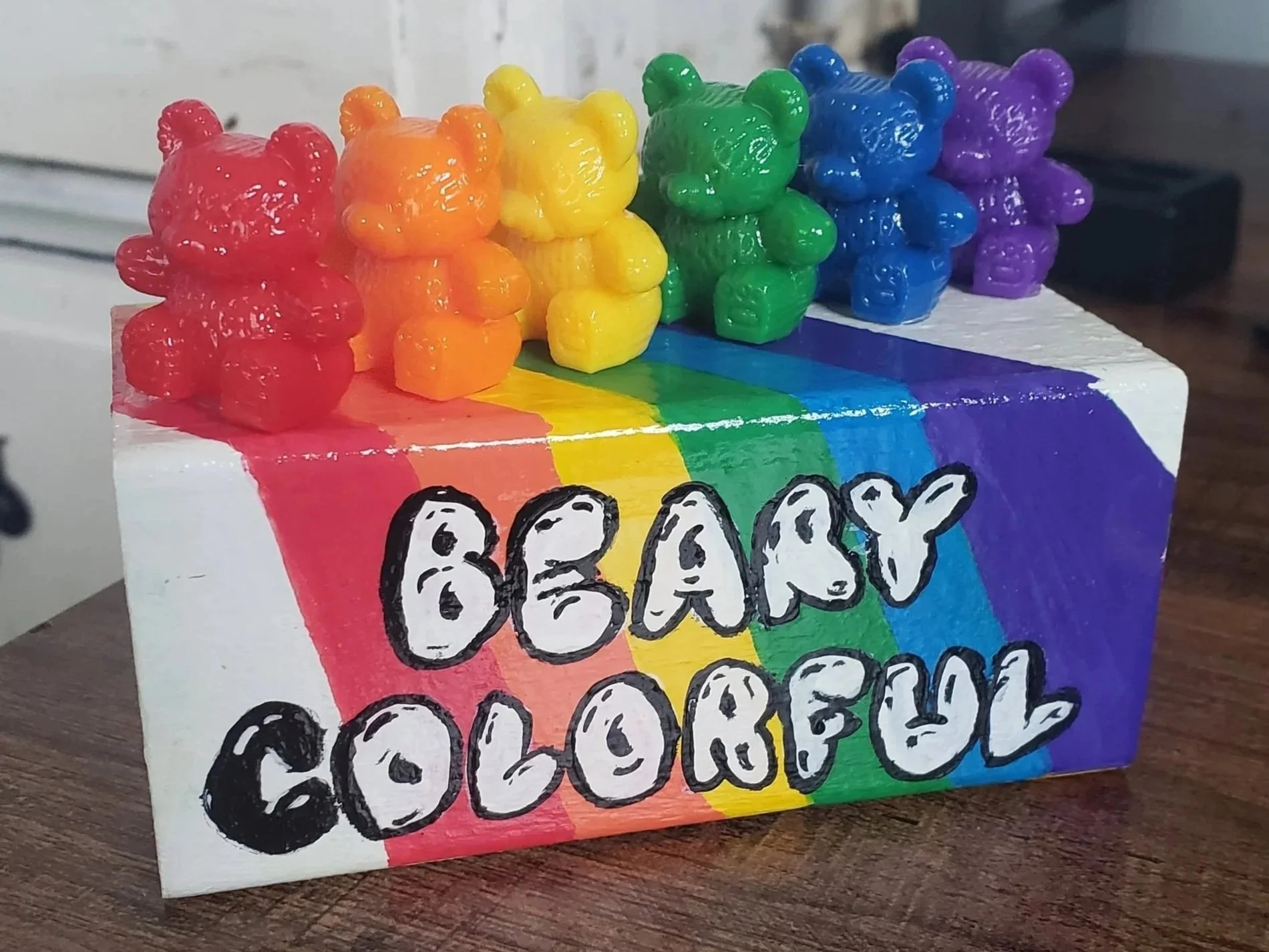 Colorful gummy bears on a rainbow-colored box with the words 'BEAR'S COLORFUL' written on it.