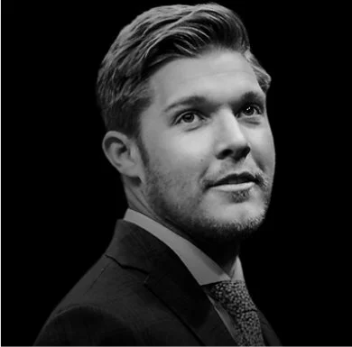 Trapper Roderick Black and white professional portrait of a young man in a suit, looking slightly to the side.