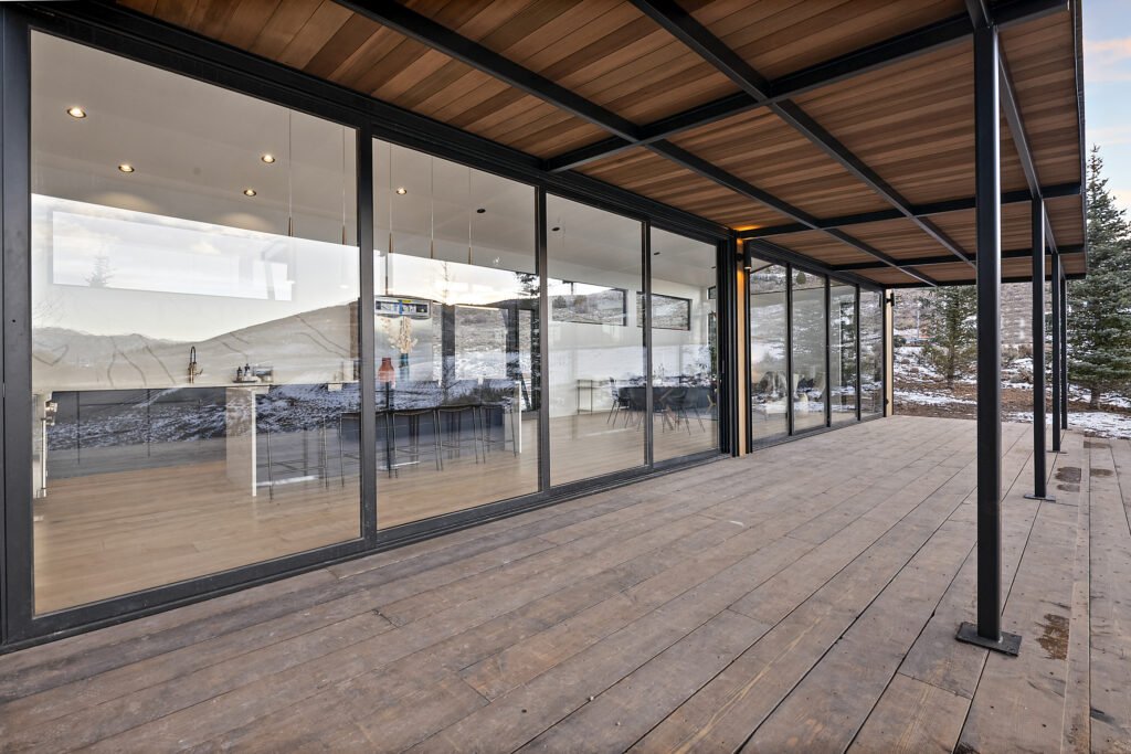 Icon-House-Benloch-Heber-City-Exterior-Covered-Deck-Sliding-Glass-Walls-Kitchen-View-Roderick-Builders-Modern-Custom.jpg