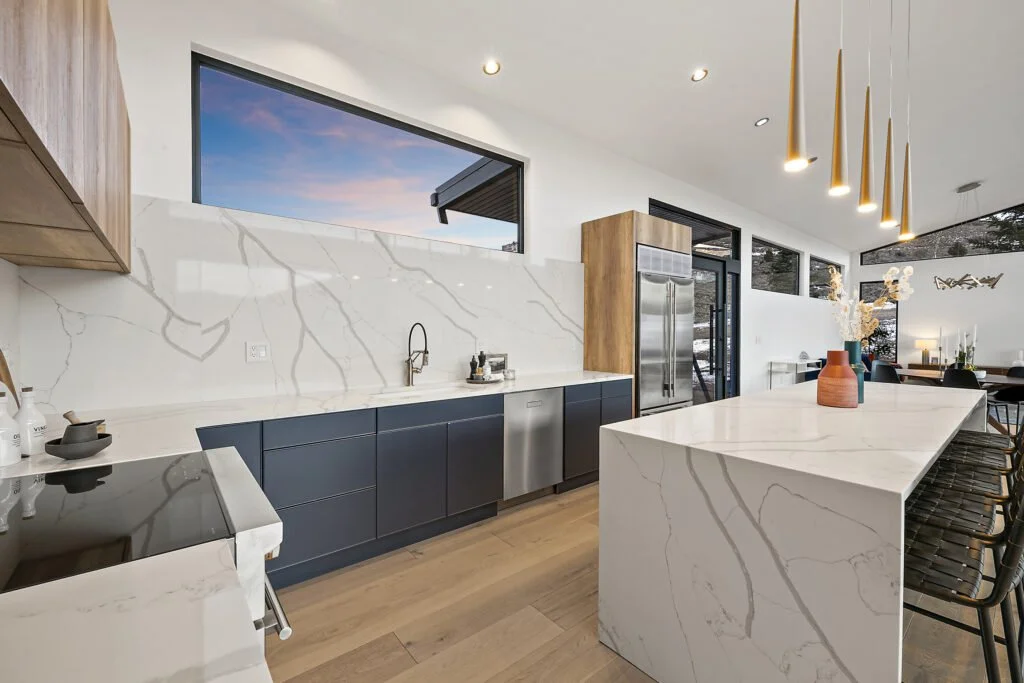 Icon-House-Benloch-Heber-City-Kitchen-Marble-Quartz-Waterfall-Island-Picture-Window-Blue-Cabinets-Roderick-Builders-Modern-Custom.jpg